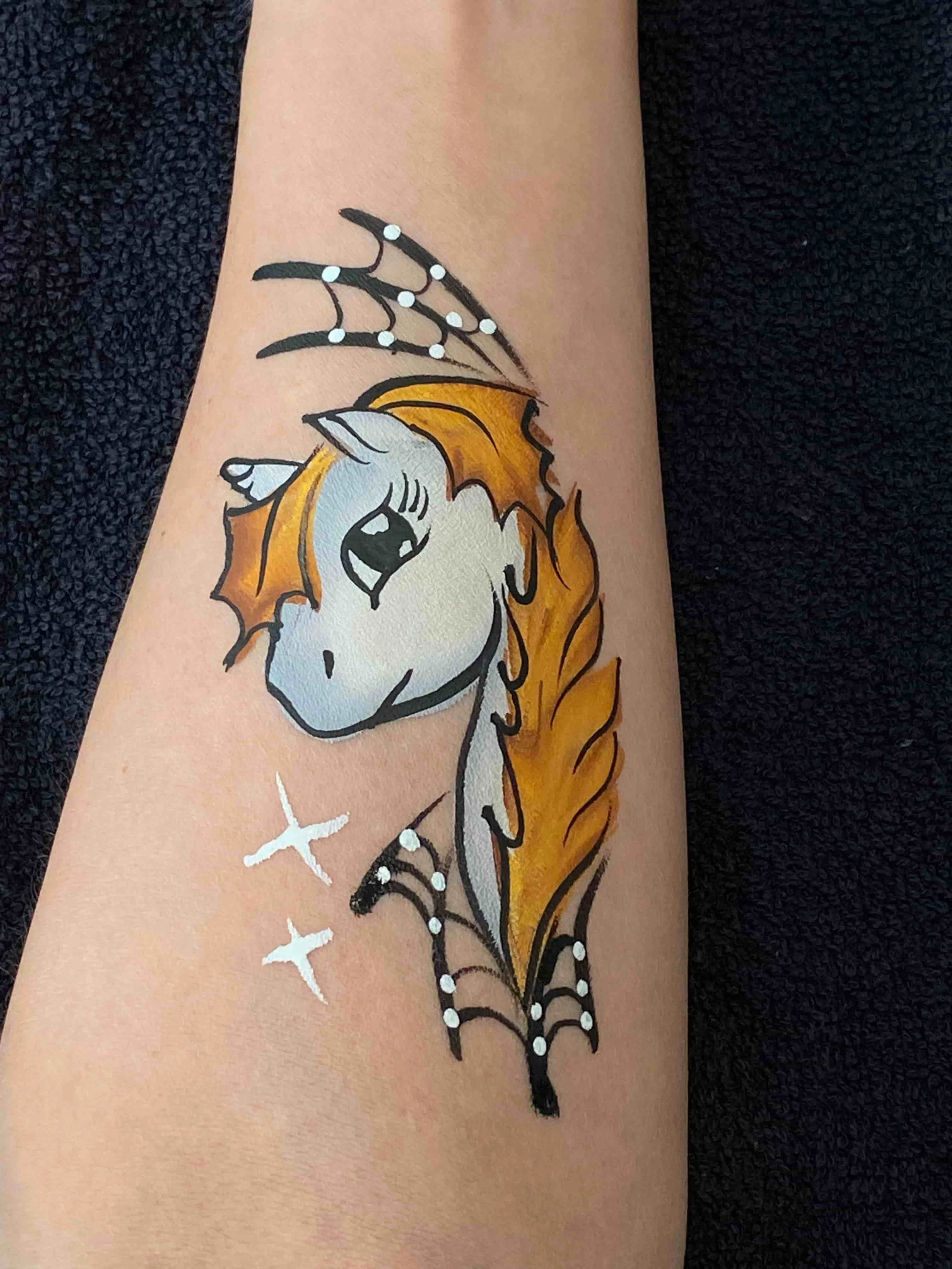 Halloween-yksisarvinen kasvomaalaus, oranssit värit ja hämähäkinseittiä