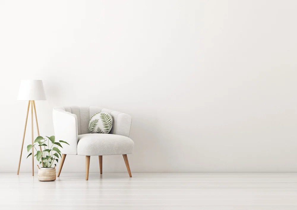 White armchair with a floor lamp and plant