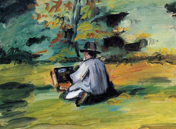 A person wearing a wide-brimmed hat, sitting on grass, reading a book, with trees and sky in the background.