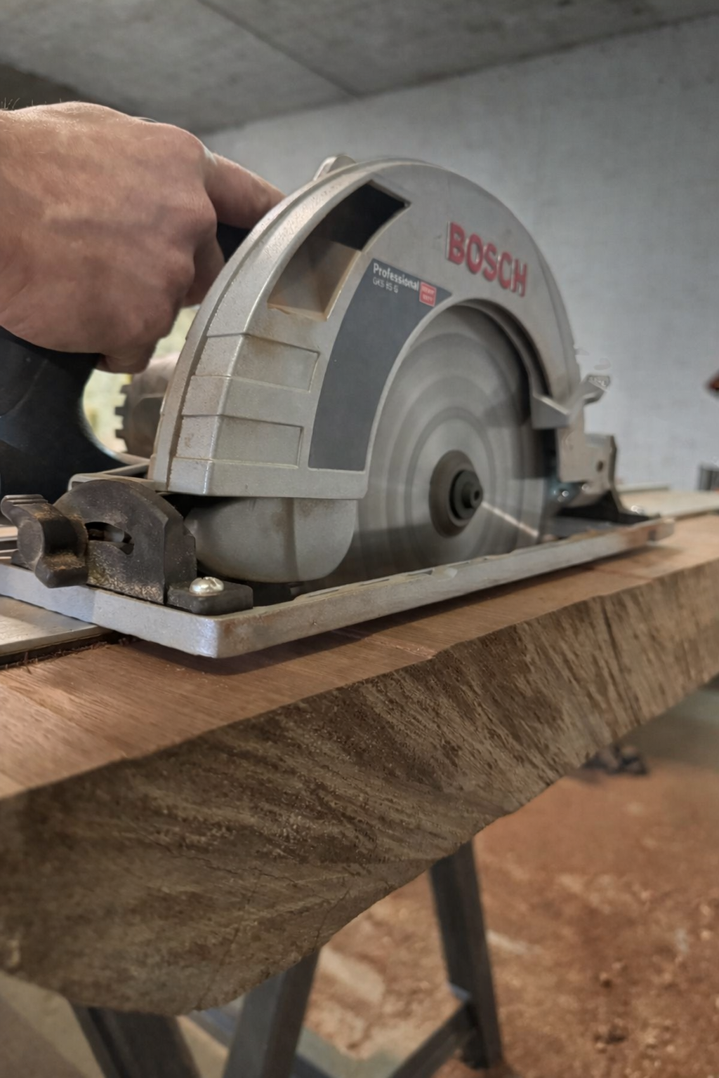 Scie circulaire Bosch, posée sur un morceau de bois, utilisée en menuiserie ou en bricolage.