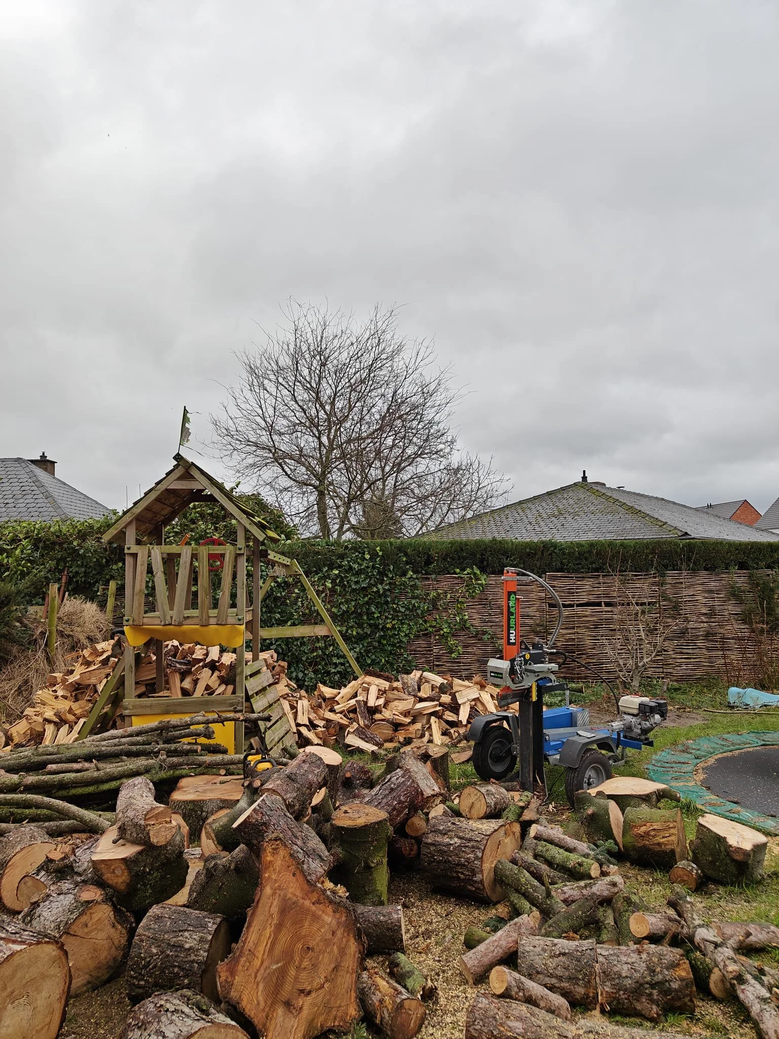 Hout in stukken wordt gekapt in een tuin.
