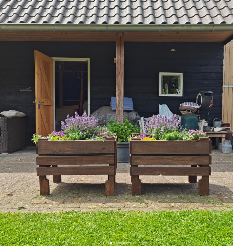 Twee houten plantenbakken met bloemen gemaakt van oude paletten door Tree Legends.