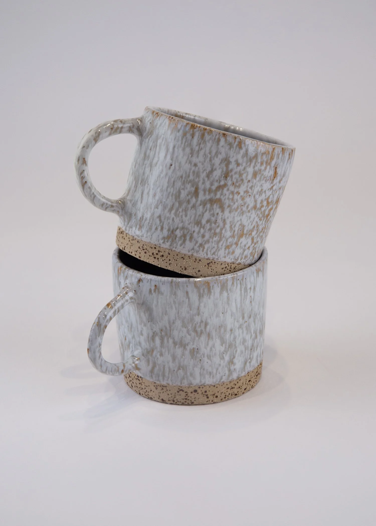 A two-piece cup set crafted from beige-white stoneware clay.