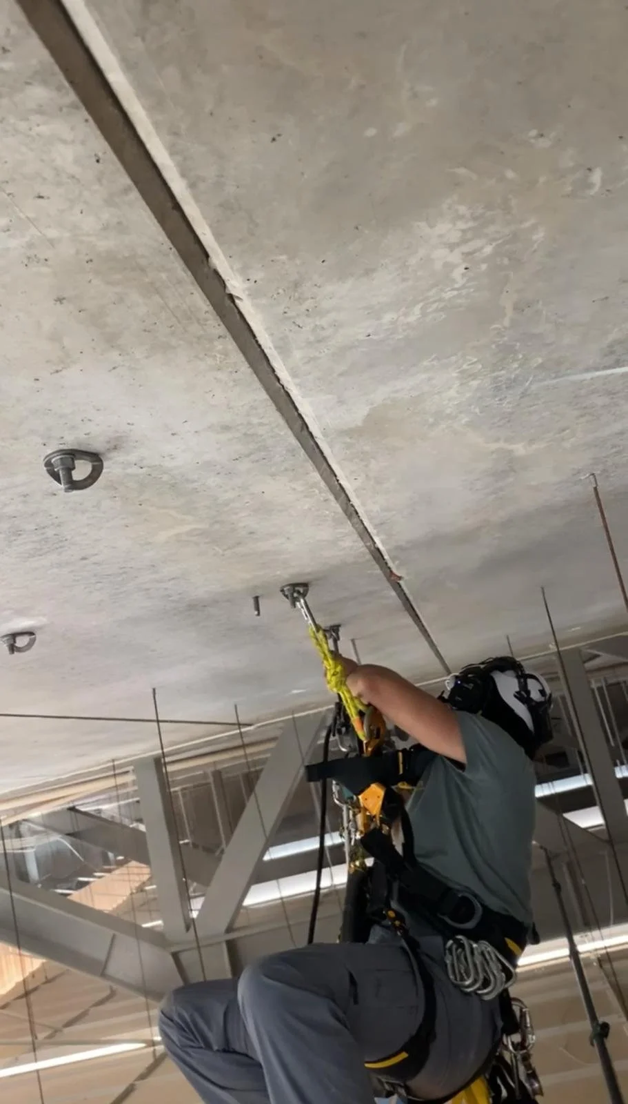 En person som arbeider med å installere eller reparere på taket, med verktøy og sikkerhetsutstyr.