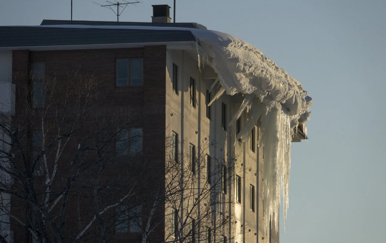 Et boligbygg med iskrystaller som henger ned fra taket.