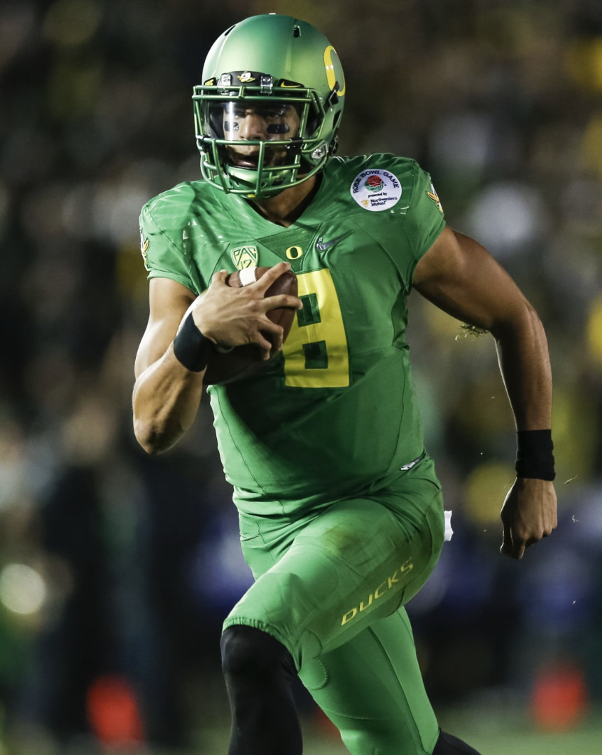 A football player in a green uniform with the number 9, wearing a helmet and holding a football, running on the field.