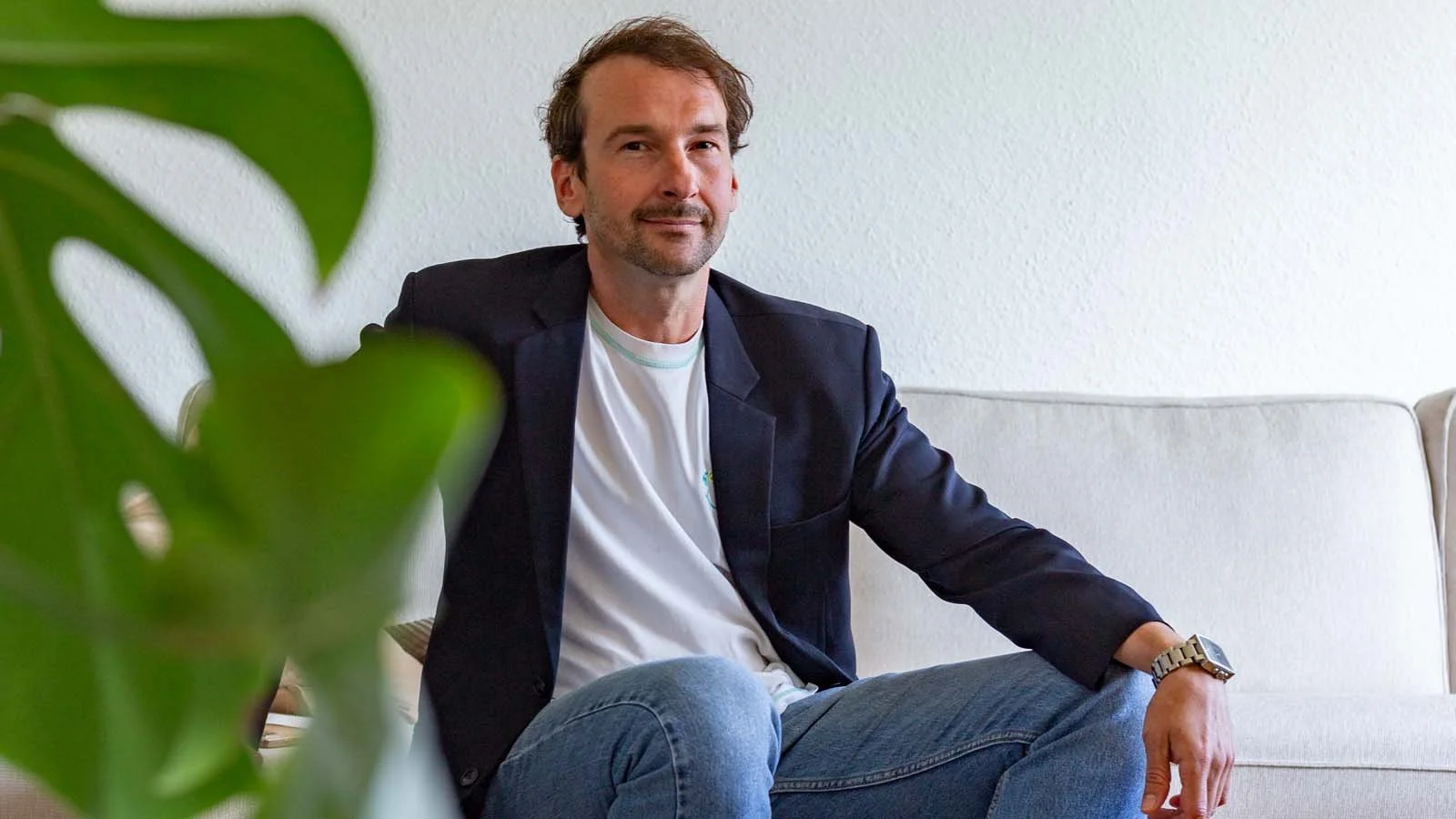 Thomas Ploch auf dem Sofa sitzend in lockerer Haltung