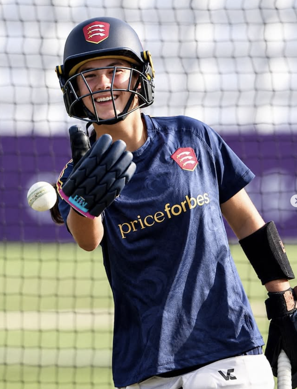 Bryony Gillgrass smiling in her Essex helmet and training shirt in the nets