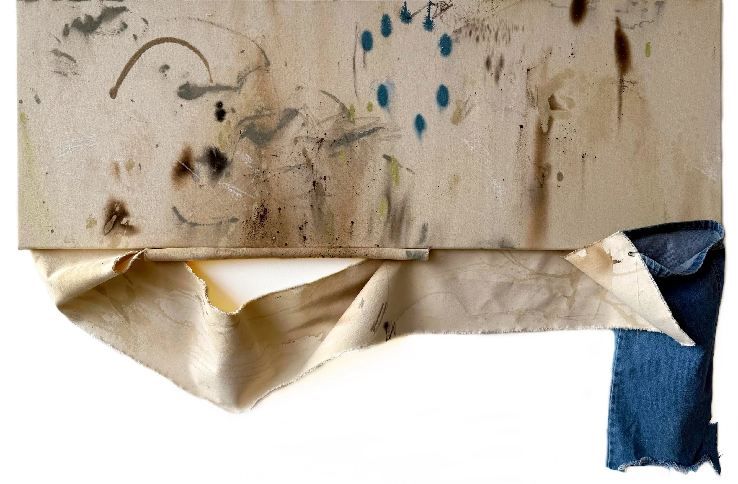 A piece of art on a canvas with abstract splashes of black, brown, and blue paint, with the edges of paper or fabric visible at the bottom.
