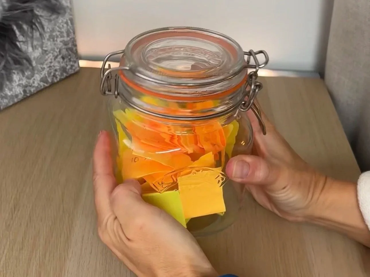 a glass kilner jar filled with yellow and orange post-it notes which have exercises written on them
