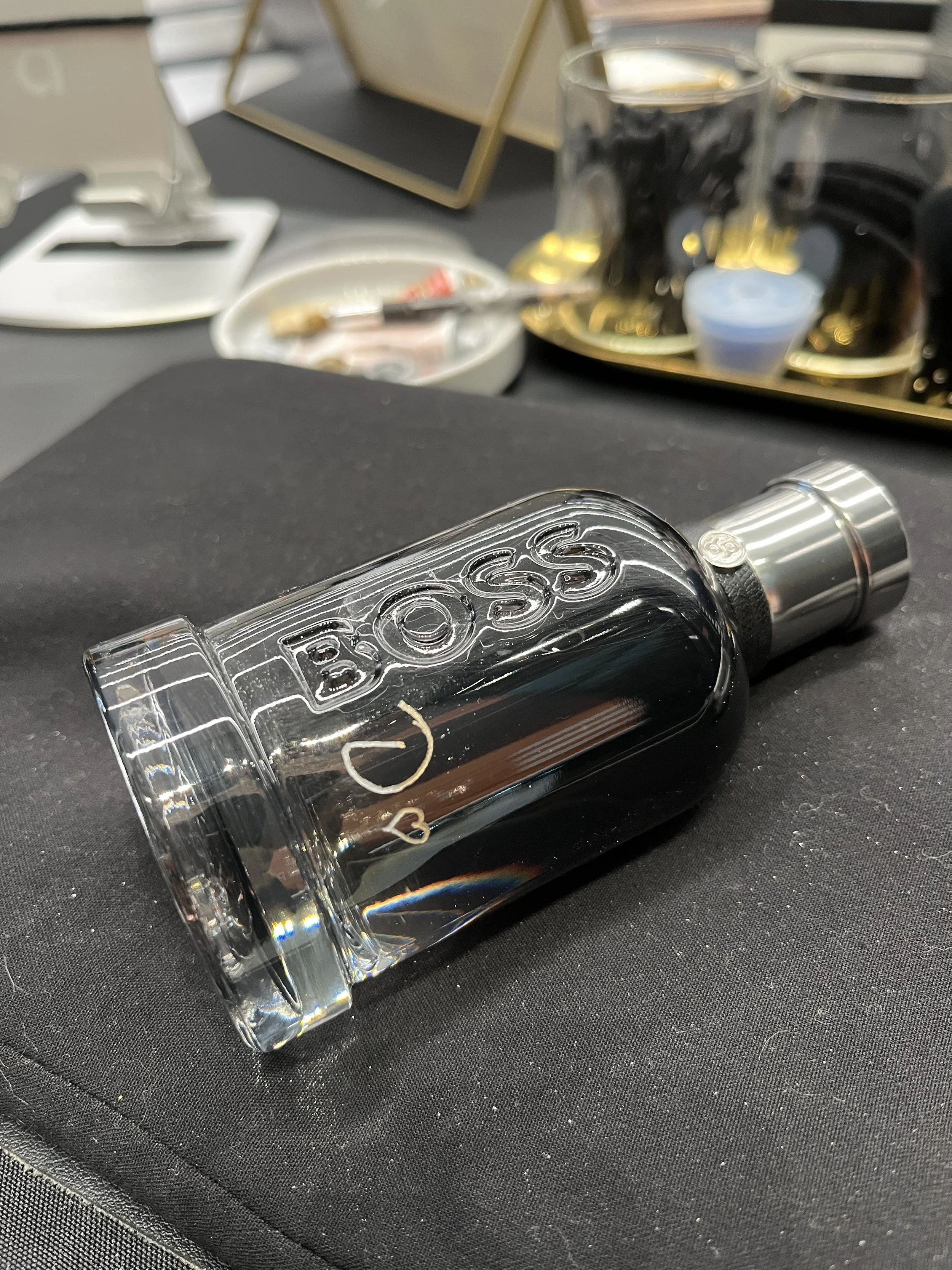 Close-up of a clear glass liquor bottle engraved for customer