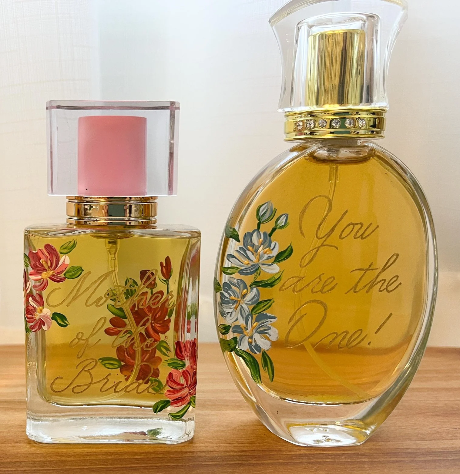 Two perfume bottles with floral decorations and inscriptions, one for a bride and one for a bridegroom.