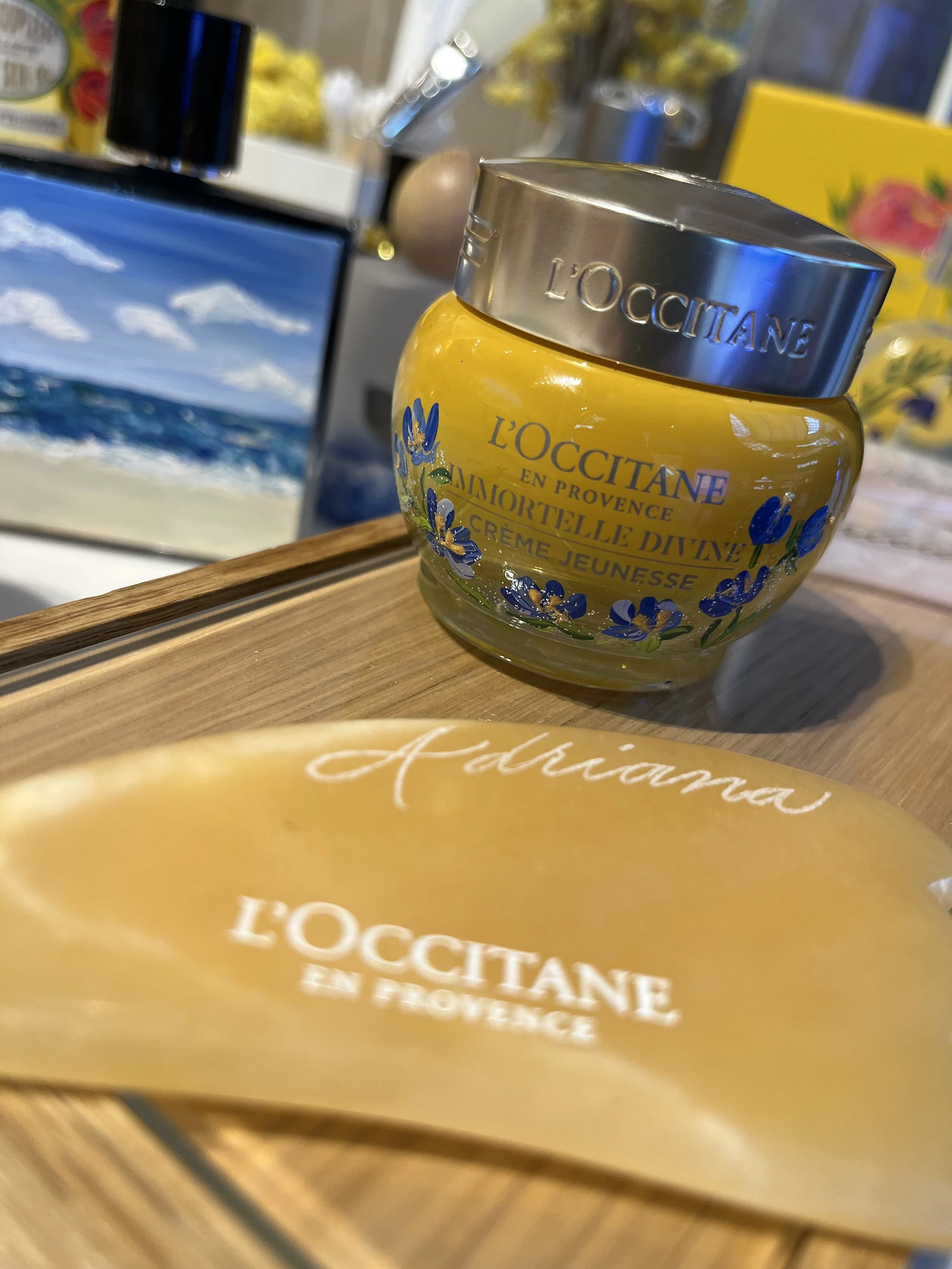 A yellow cosmetic jar with a silver lid labeled 'L'OCCITANE EN PROVENCE