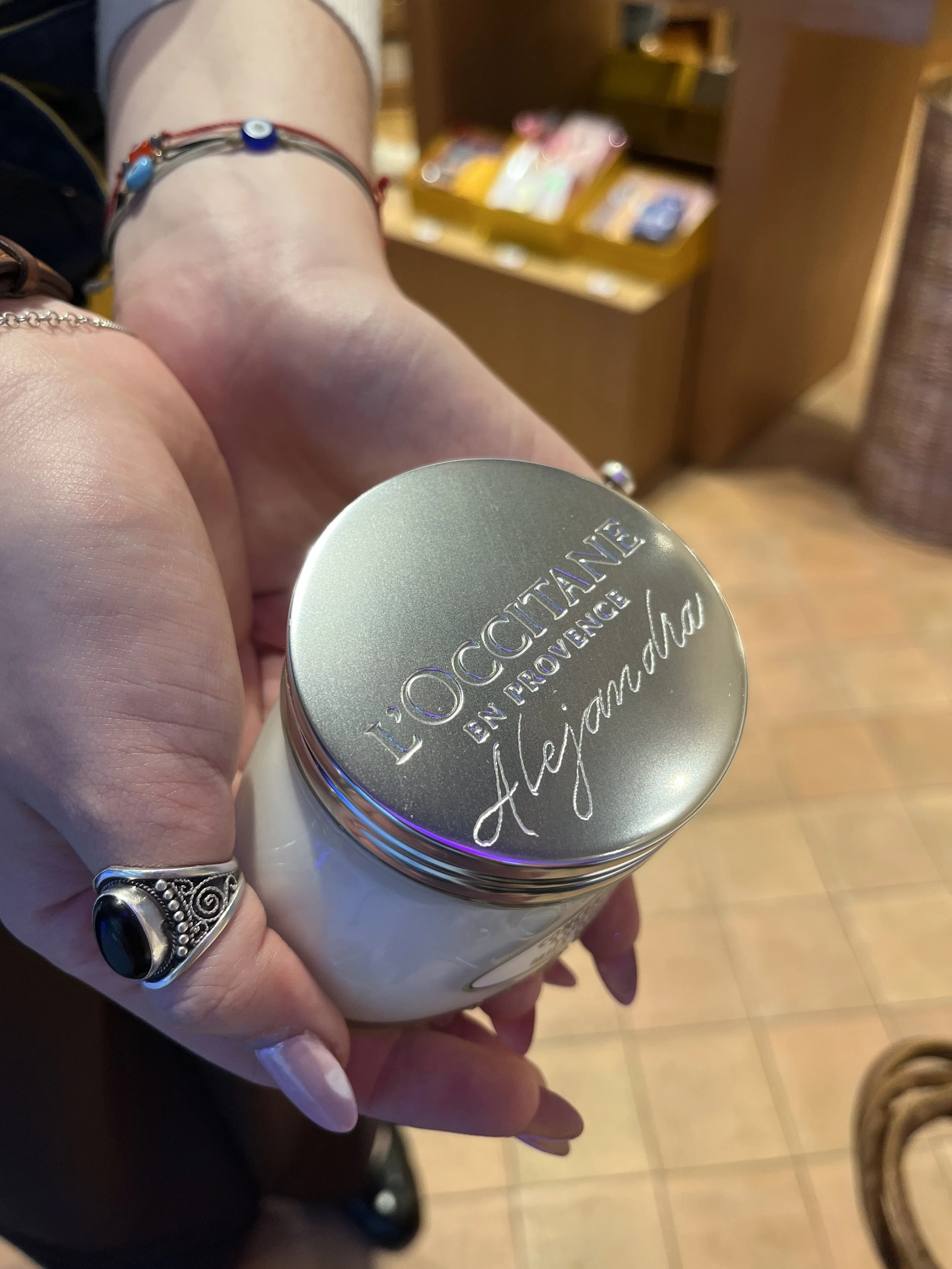 Client holding L'Occitane product with engraved name.