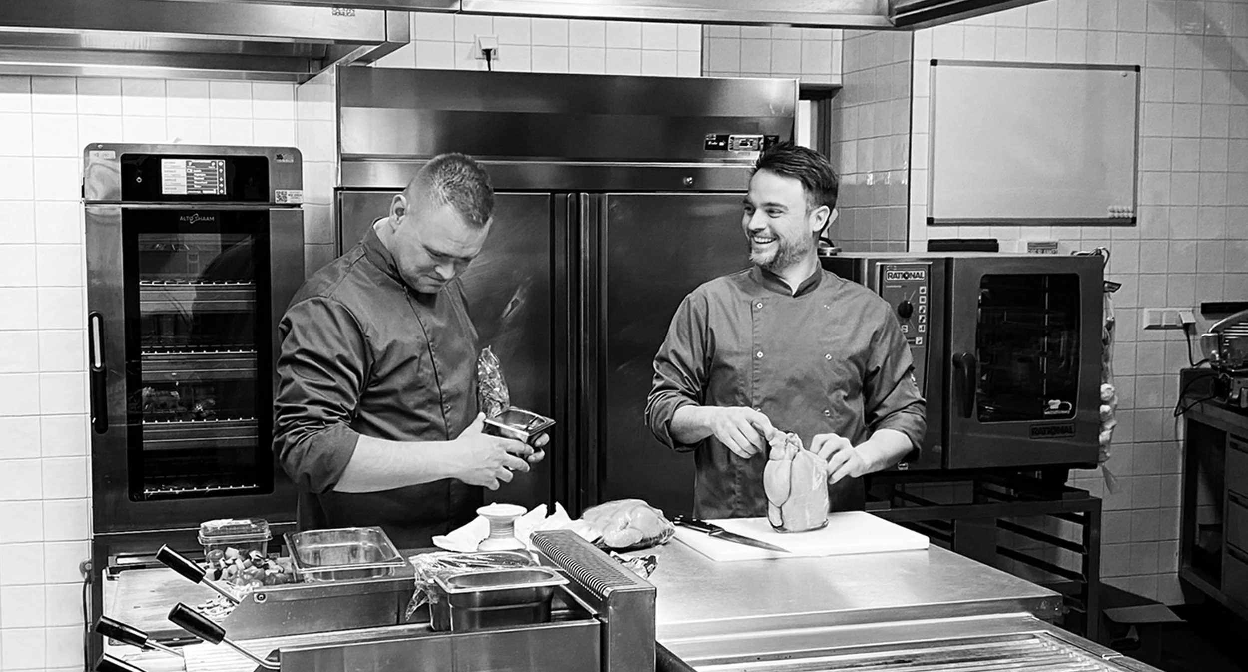 Twee koks staan in de keuken van Heisa, ze lachen naar elkaar en bereiden het diner.