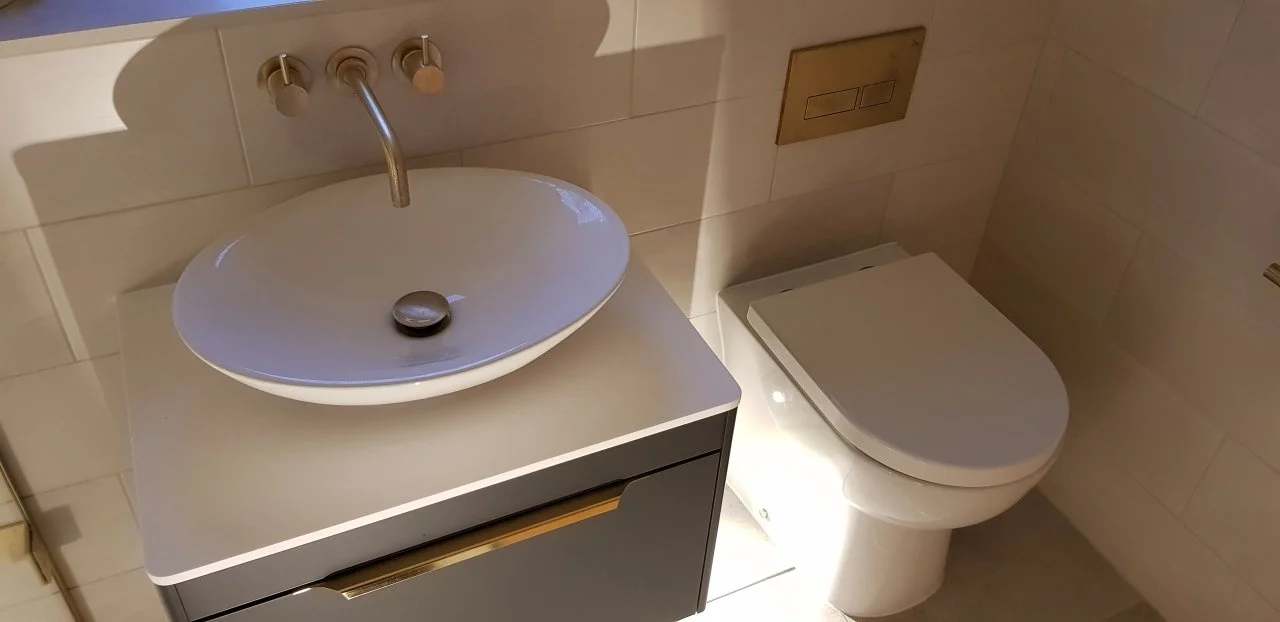 Contemporary wet room and bath installation in Cheltenham with brushed brass fittings and tiled floor