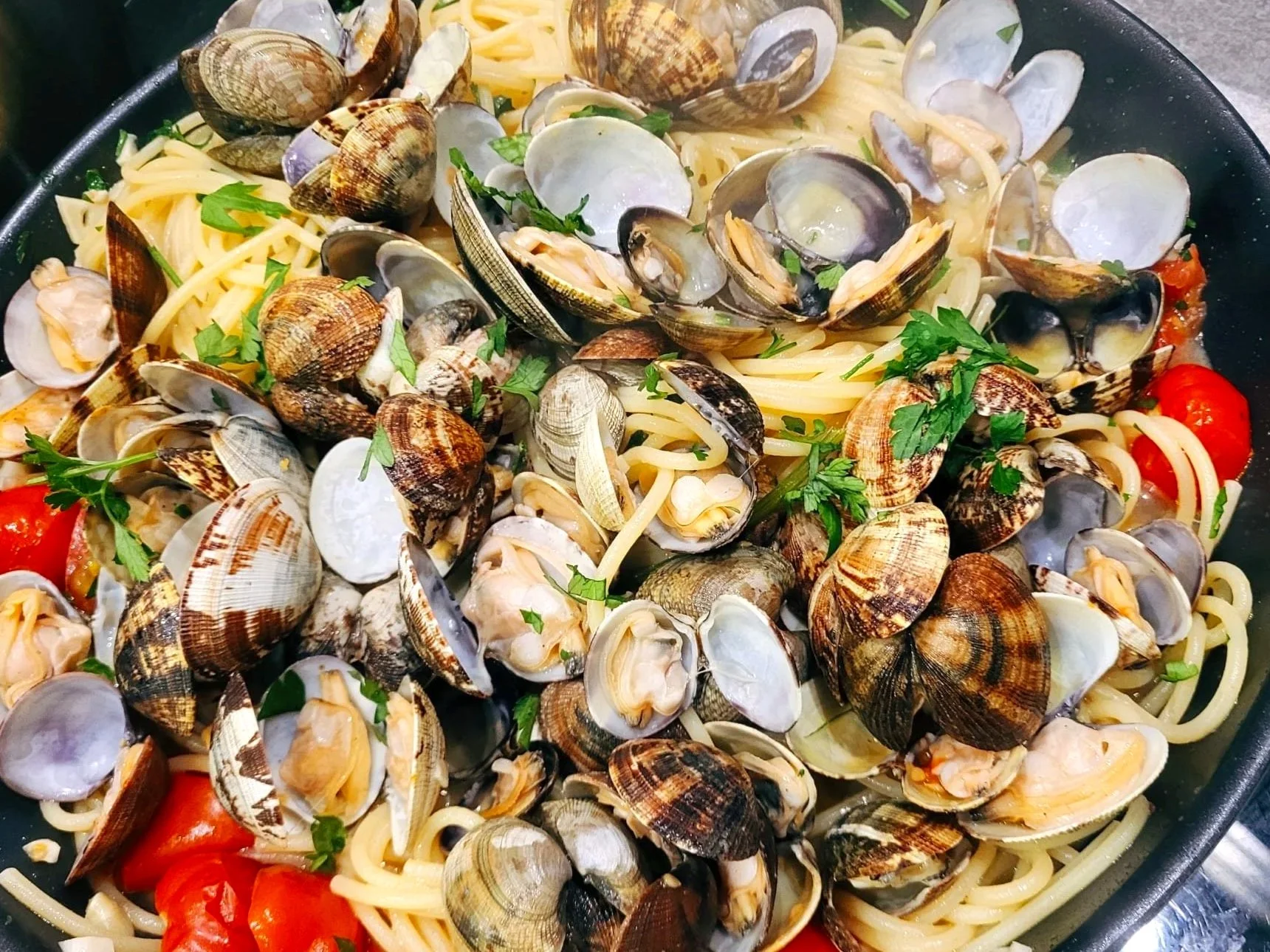 Borden met spaghetti met schelpdieren zoals mosselen, garnalen, tomaat en verse kruiden