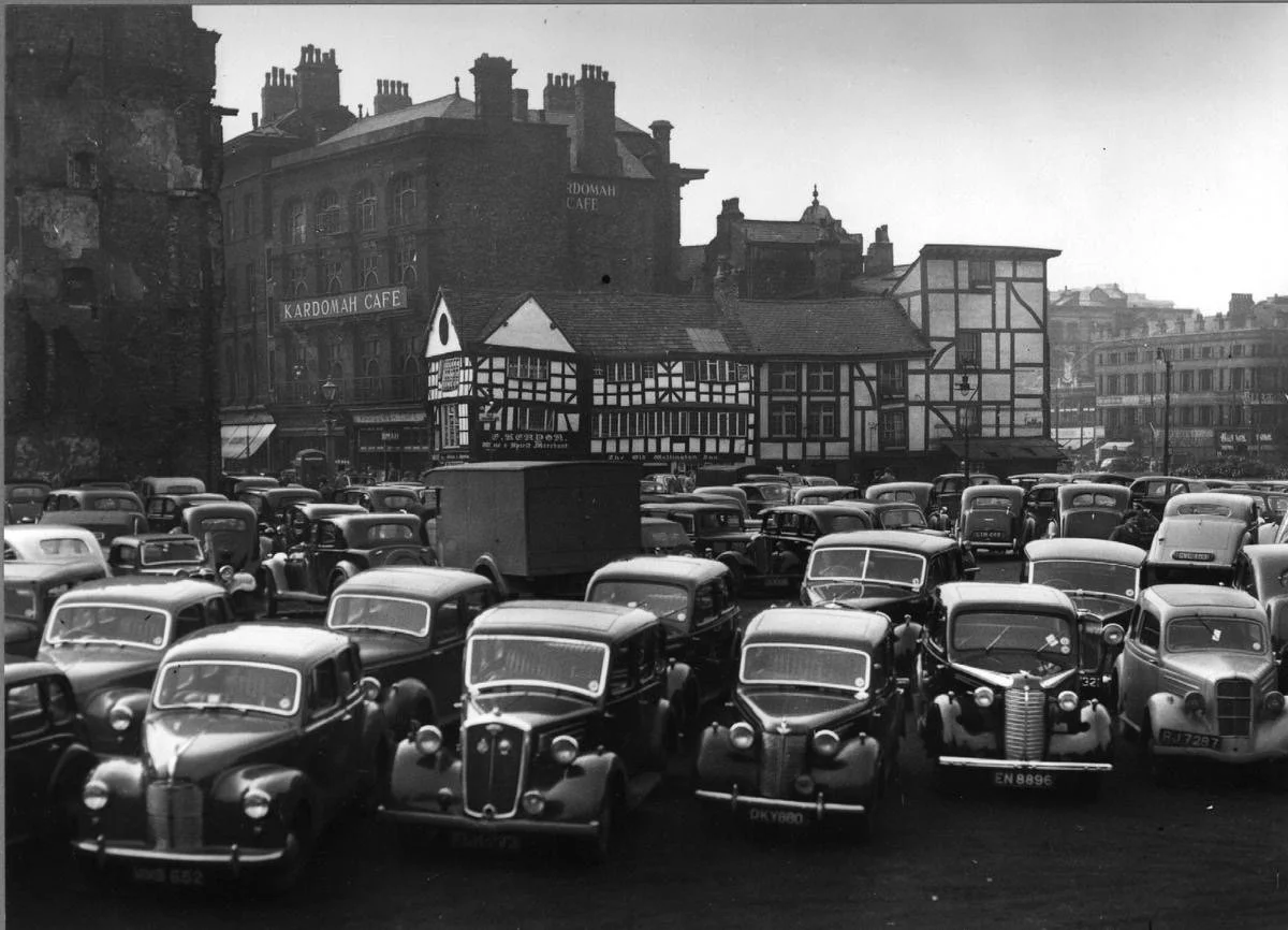 For years after World War II, gaps left by the Manchester Blitz became car parks&hellip; and this photograph from 1950 captures that perfectly. Selfridges now occupies this exact spot.

Beyond those fantastic cars are the Old Wellington and Sinclair&