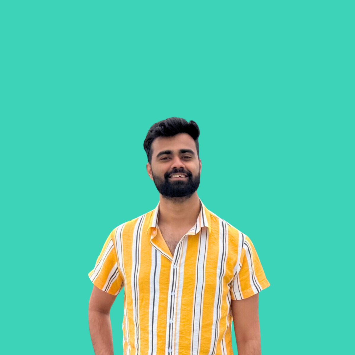 A man with dark hair, beard, and a yellow striped shirt standing against a teal background.