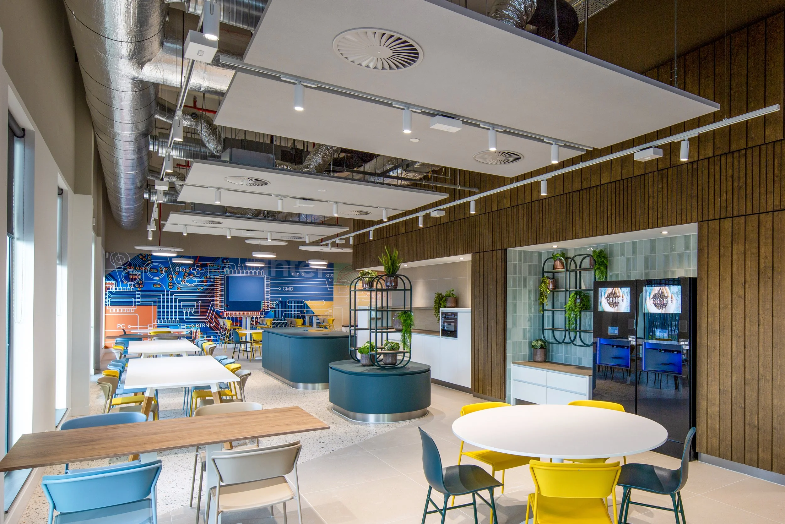 Interieur van een moderne kantine in Amsterdam met kleurrijke meubels, een design plafond en decoratieve planten gefotografeerd door interieurfotograaf John van Groenedaal.