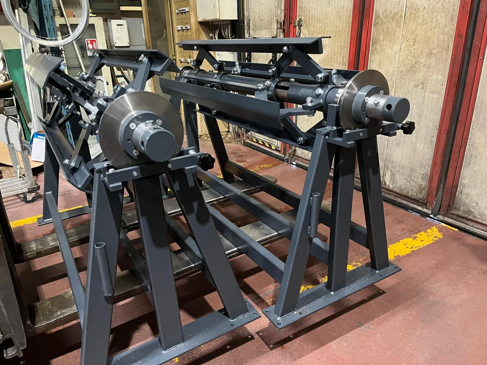 Struttura metallica industriale con motore e componenti meccanici in un'officina.