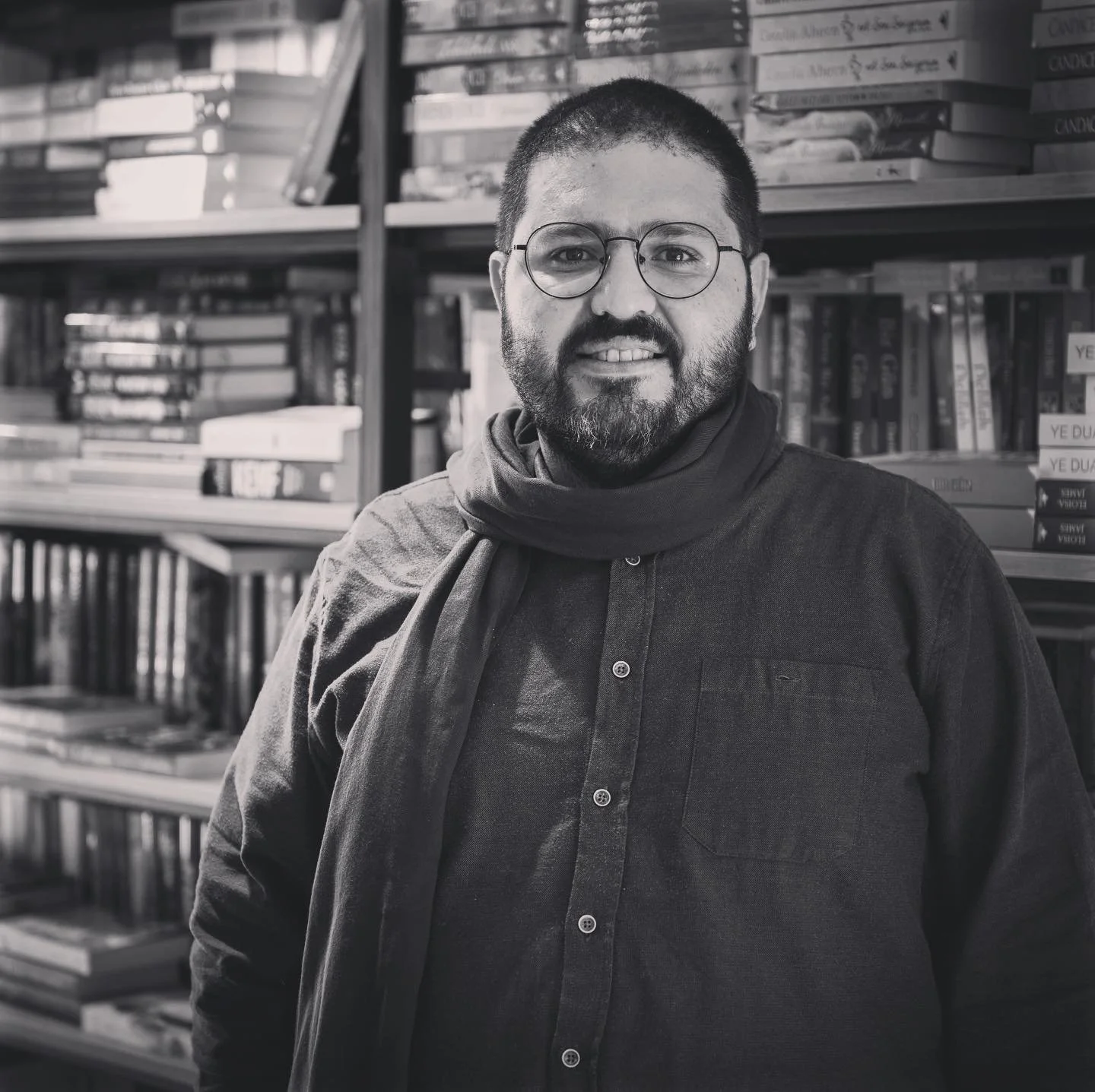 Woman painting on a large beige canvas at night, with art supplies on a small table nearby.