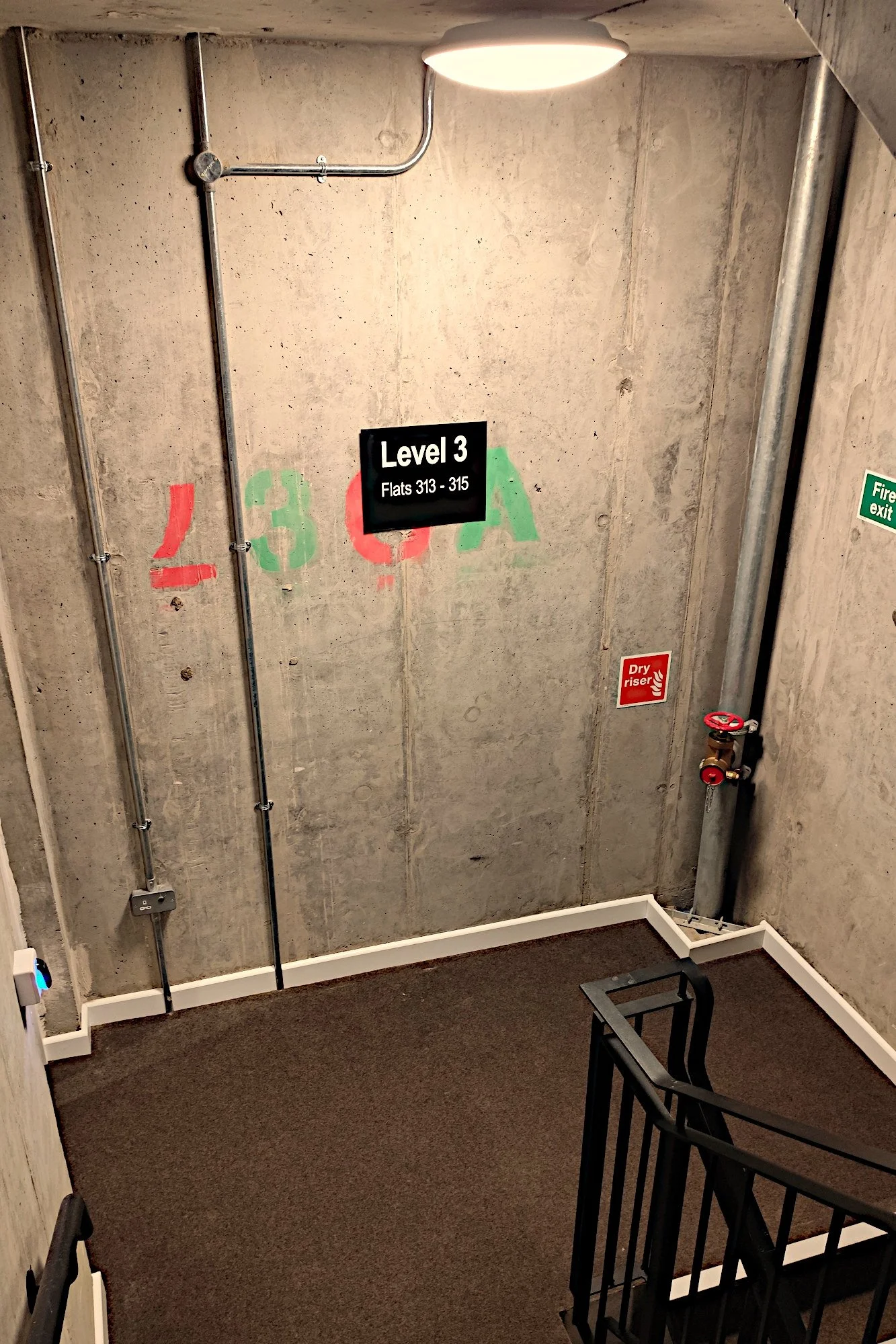 concrete stairwell with hard wearing carpets and concrete ceilings