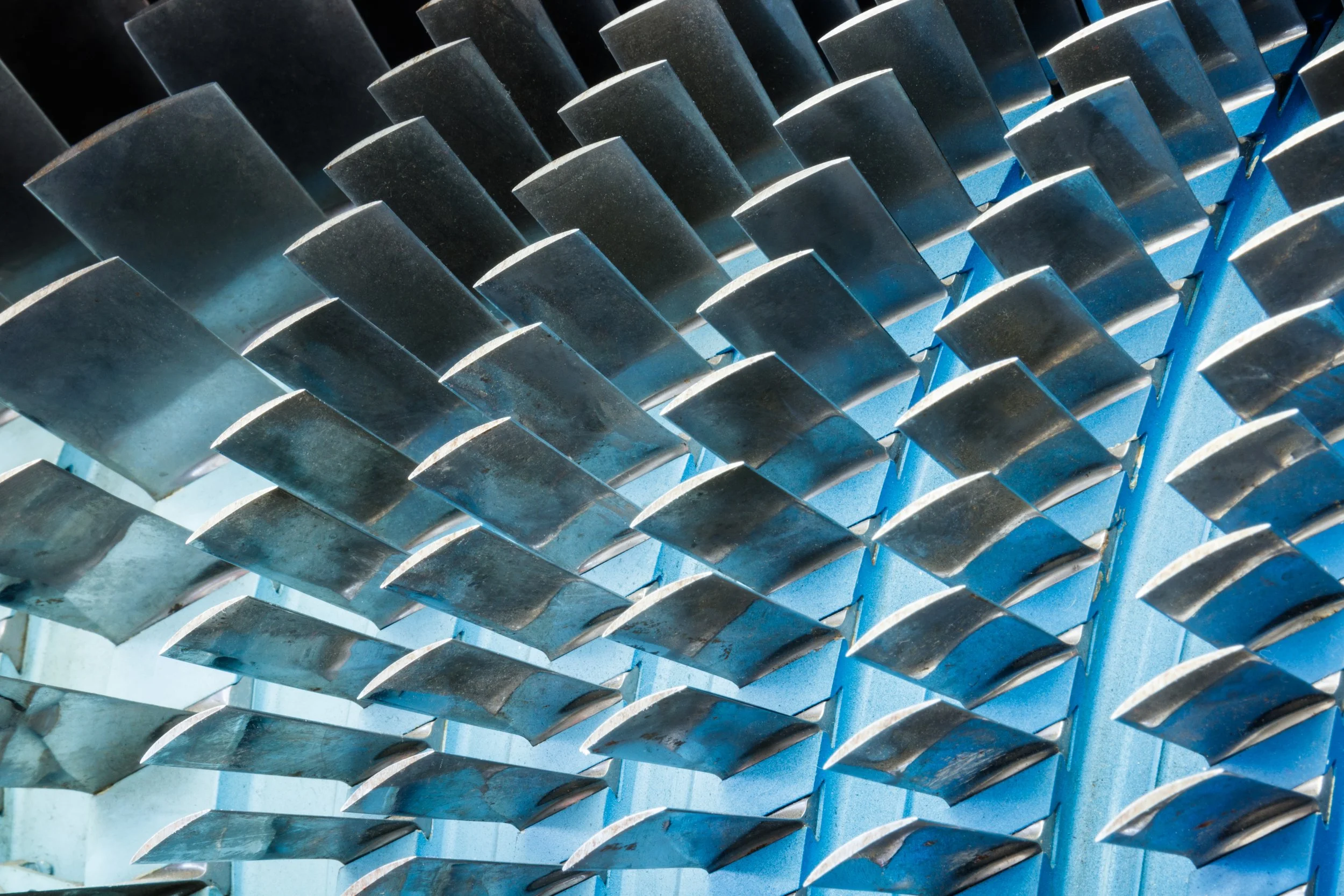 Close-up view of a metallic wind turbine blade's internal structure with blades arranged in a spiral pattern.