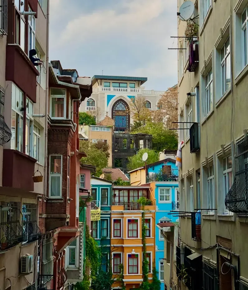 Colorful residential buildings on a hillside, viewed from a narrow alley.