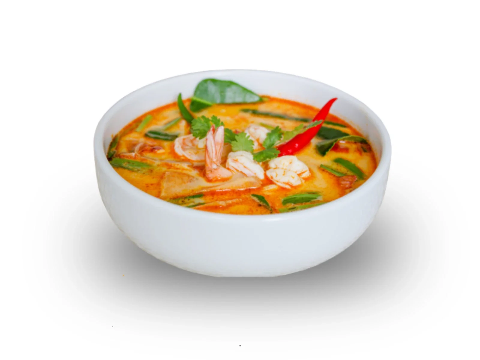 Bowl of spicy shrimp and vegetable soup garnished with cilantro, red chili, and lime wedge on a white background.