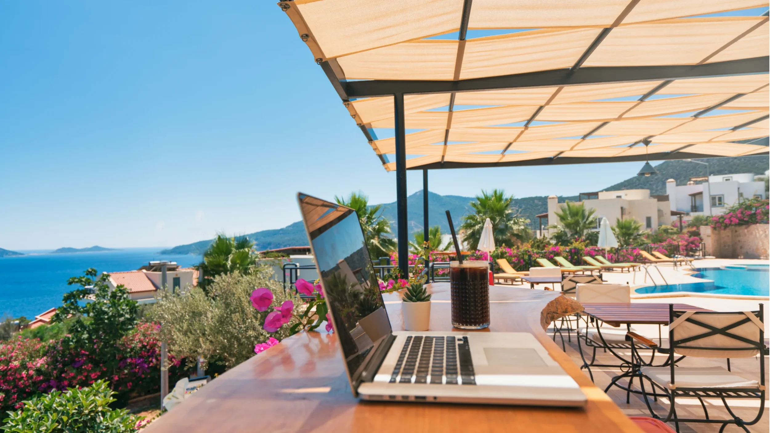“Professional working remotely with laptop in a scenic destination — bleisure travel and workation trend.”