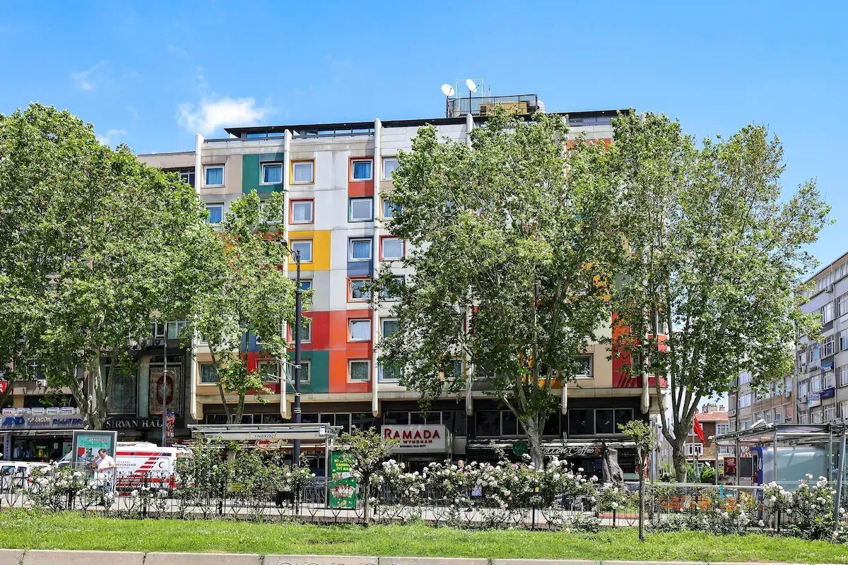 Colorful multi-story building with trees and a park in front