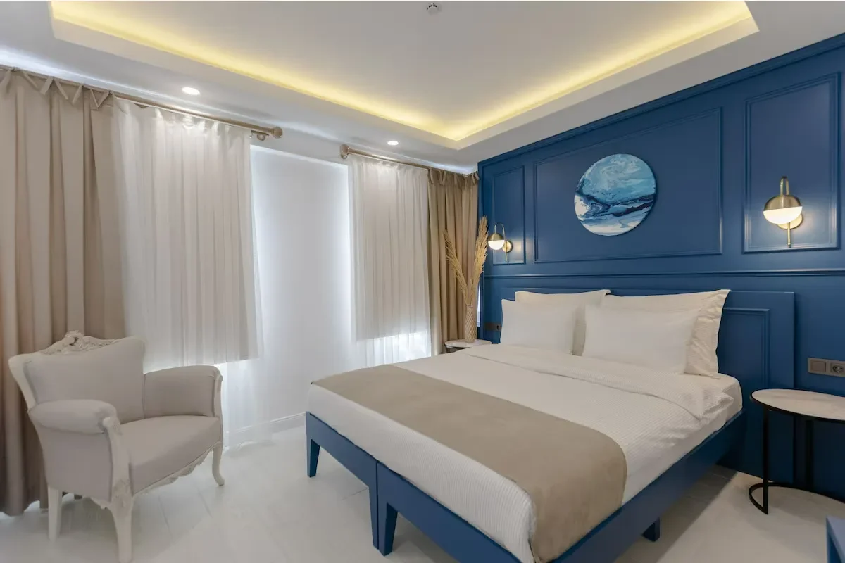 a twin size bed room with blue painting and close curtains in kiana kaleici hotel antalya