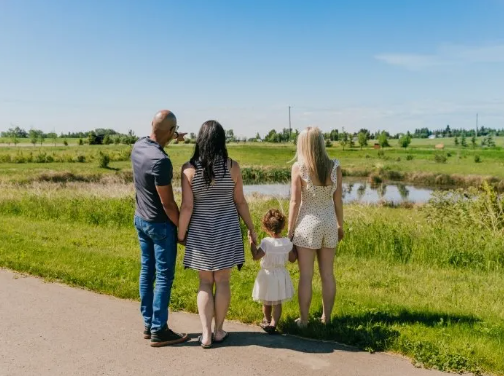 a family watching the lake in liberty landing, a community in Red Deer County