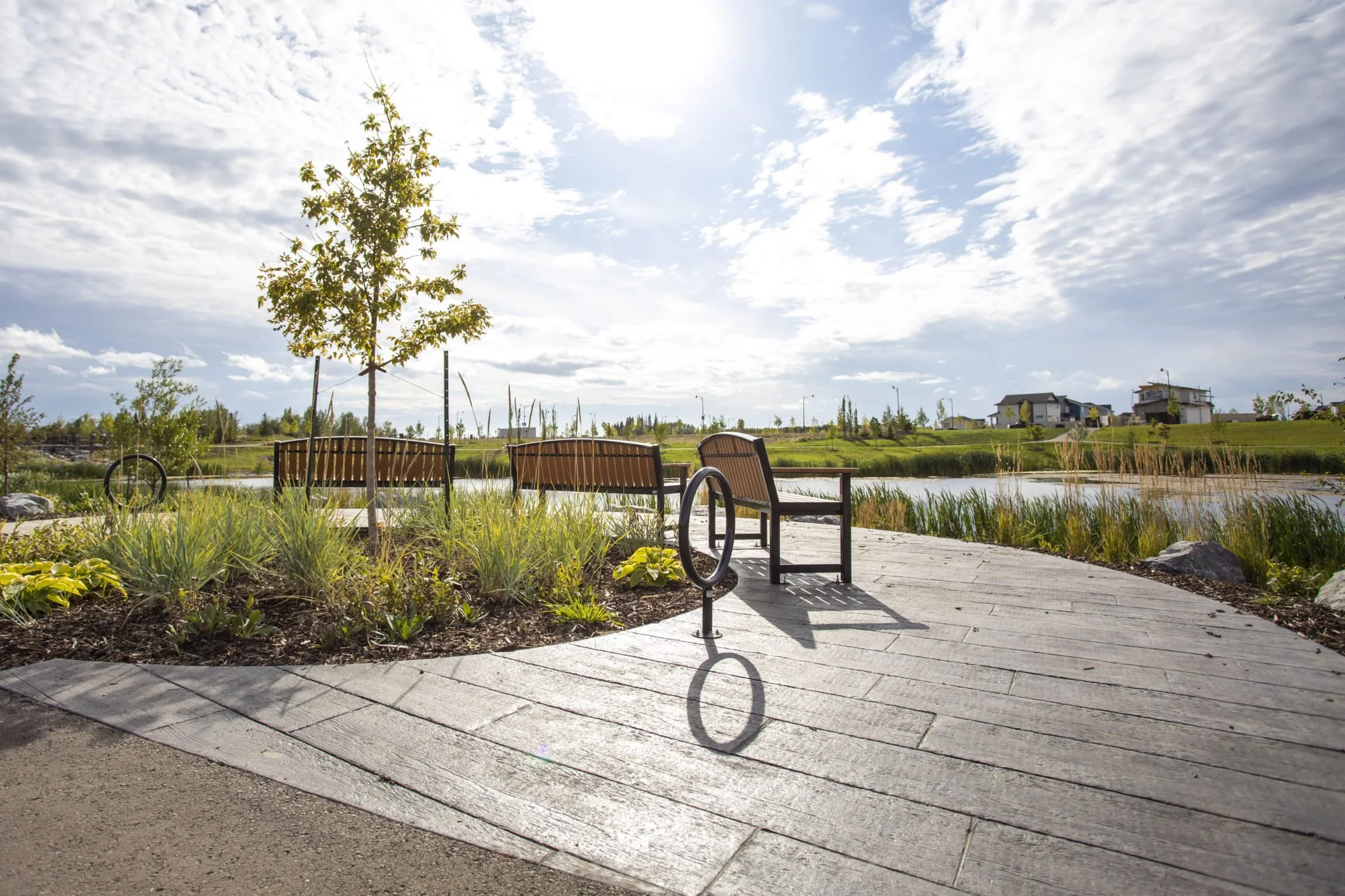 Park benches and a water feature in Evergreen, a community in Red Deer Alberta