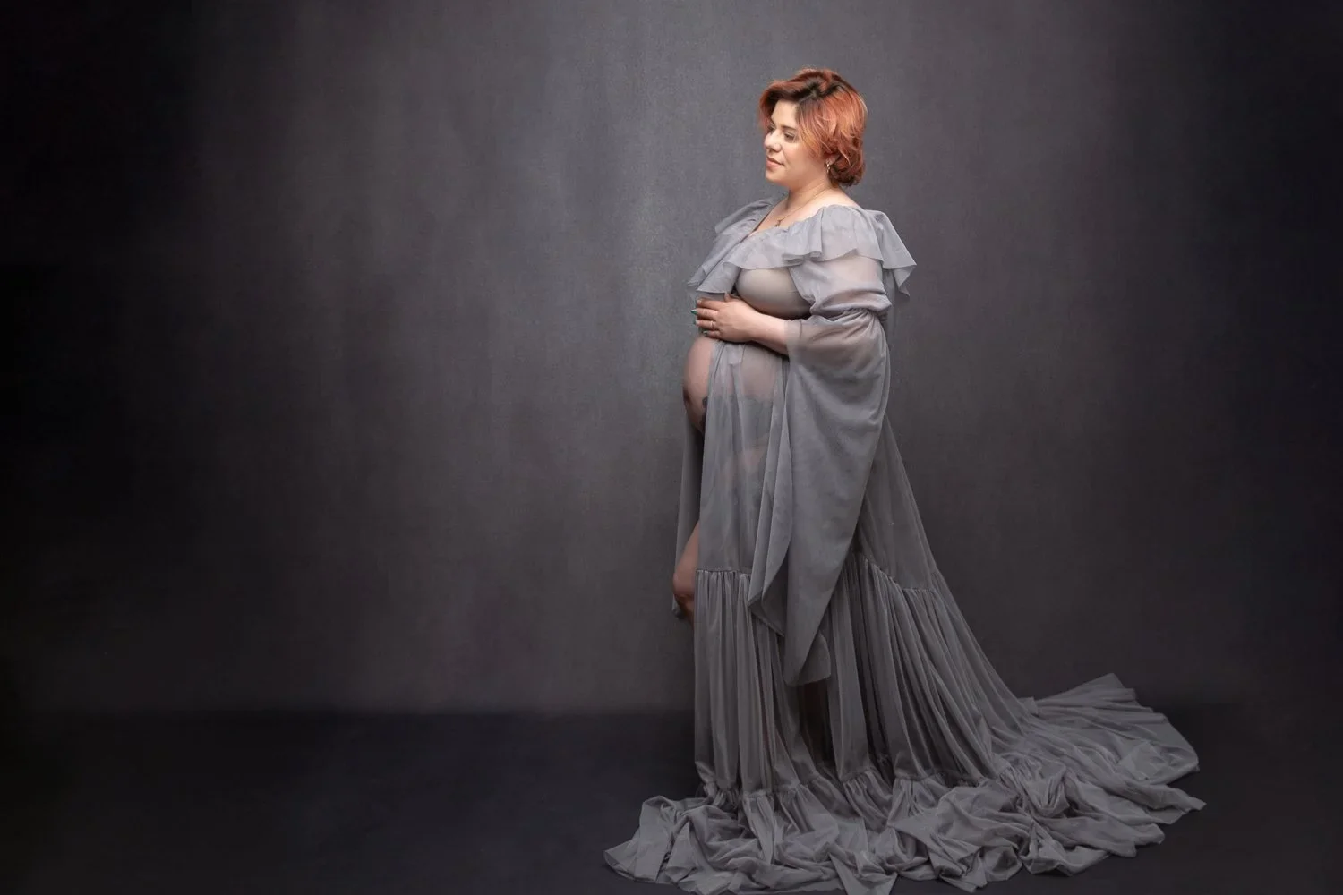 Delicate Mama 
 Color:  Gray  Size:  Average  Coverage:  Partial Coverage 

This gown has a long skirt with slightly ruffled tail, and long imperial sleeves. It is open in the front to allow for exposed belly. Nude panties and strapless work best for