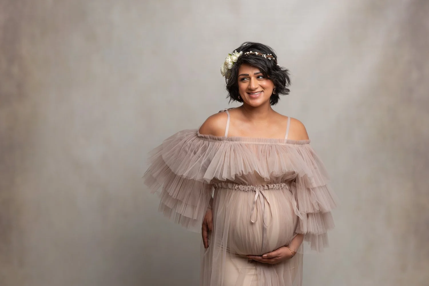 Pregnant woman smiling in a glamorous photo shoot
