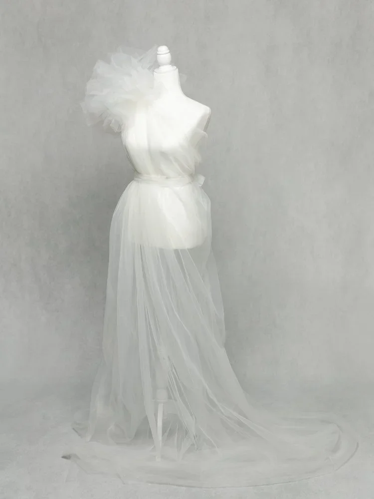 Vogue Mama 
 Color:  White  Size:  Average  Coverage:  Partial Coverage 

This tulle gown falls on one shoulder with a very dramatic accent. It falls almost straight all the way to the floor. Nude panties and strapless work best for this dress.