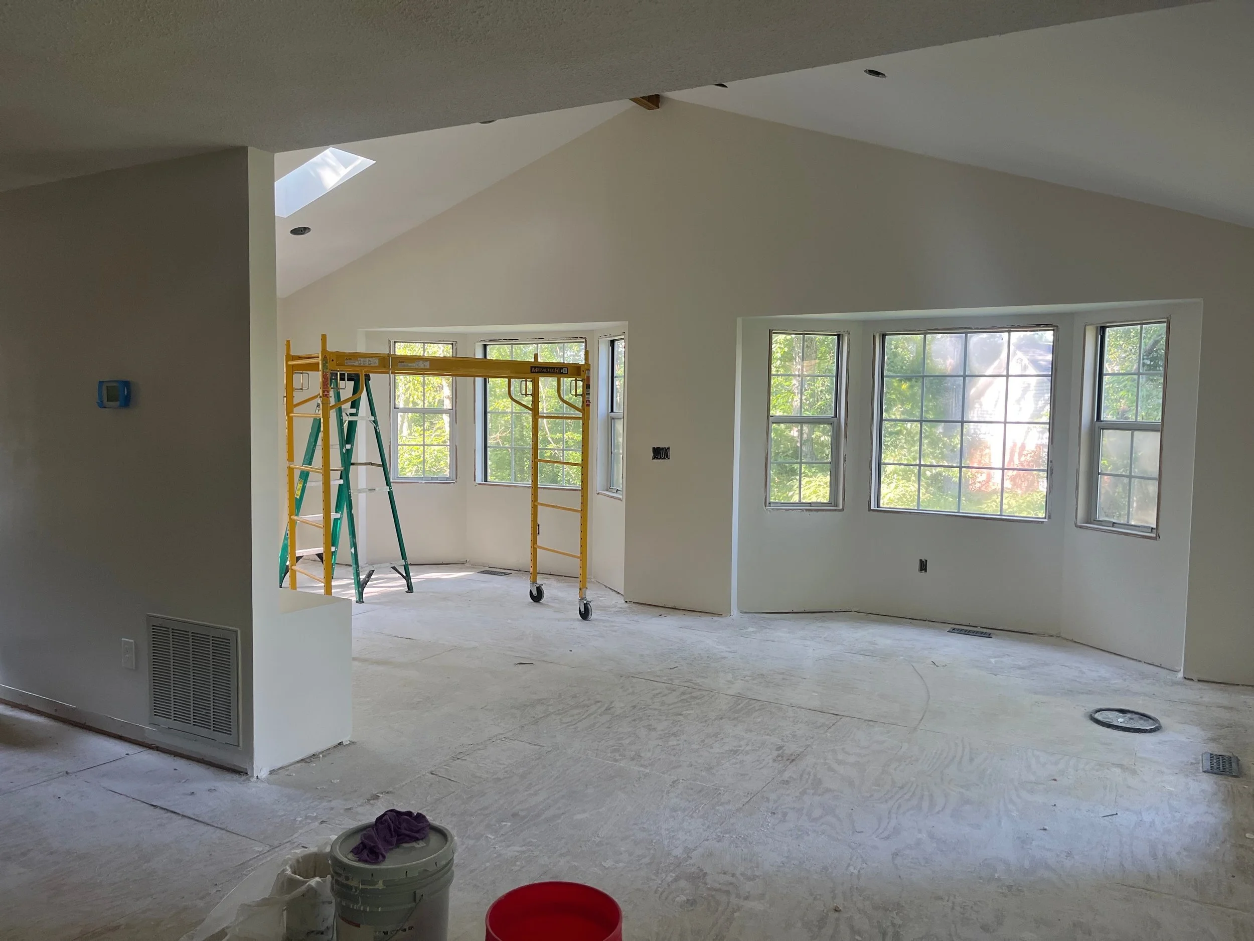 Vaulted great room addition under construction with scaffolding and a curved bay window