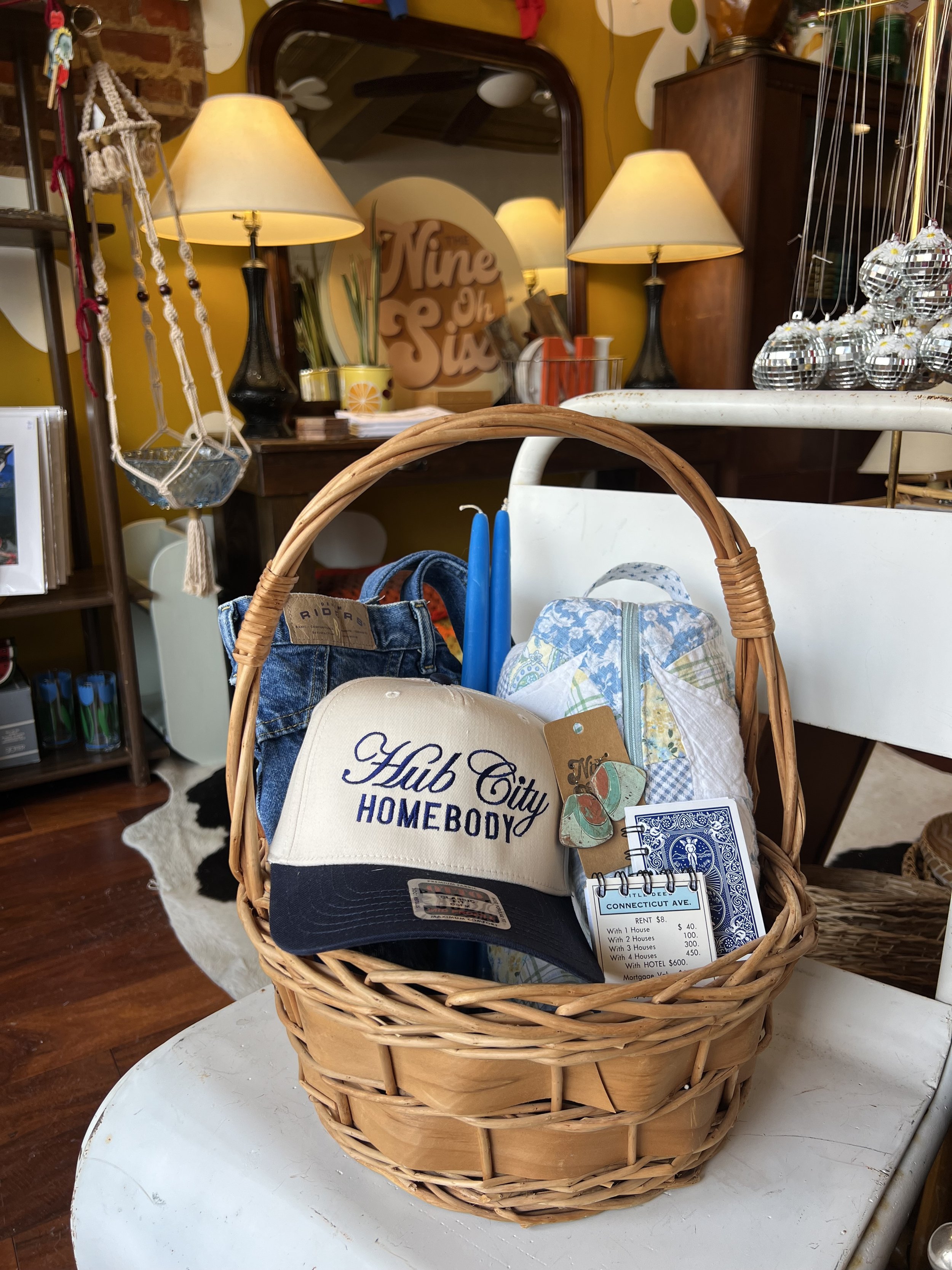 A retro-style graphic design with the text 'The Nine Oh Yeah' in stylized pink and brown lettering, surrounded by white flowers with yellow centers and smaller star-like shapes with a warm, gradient background.