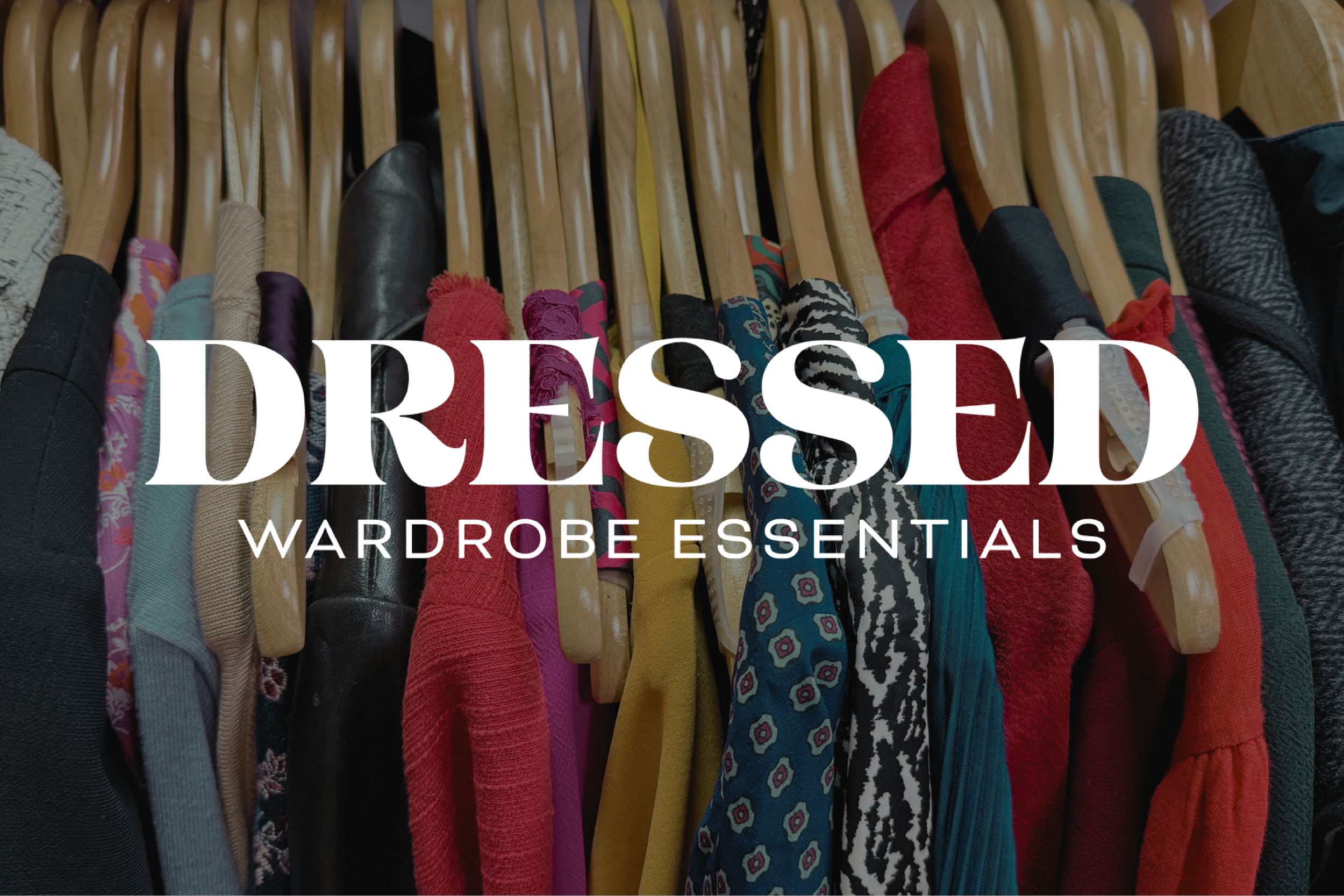A row of colorful dresses hanging on wooden coat hangers with the words 'DRESSED Wardrobe Essentials' overlayed in white text.