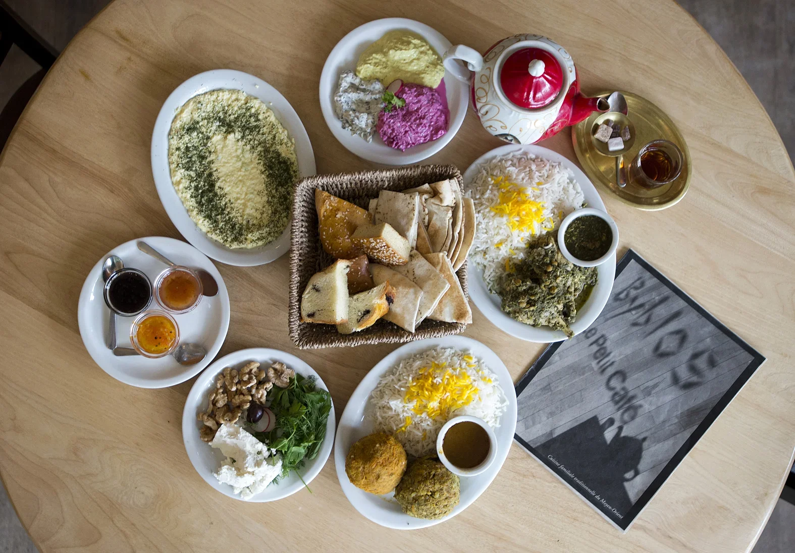 Repas traditionnel iranien avec riz, salades, pains, légumes, et thé
