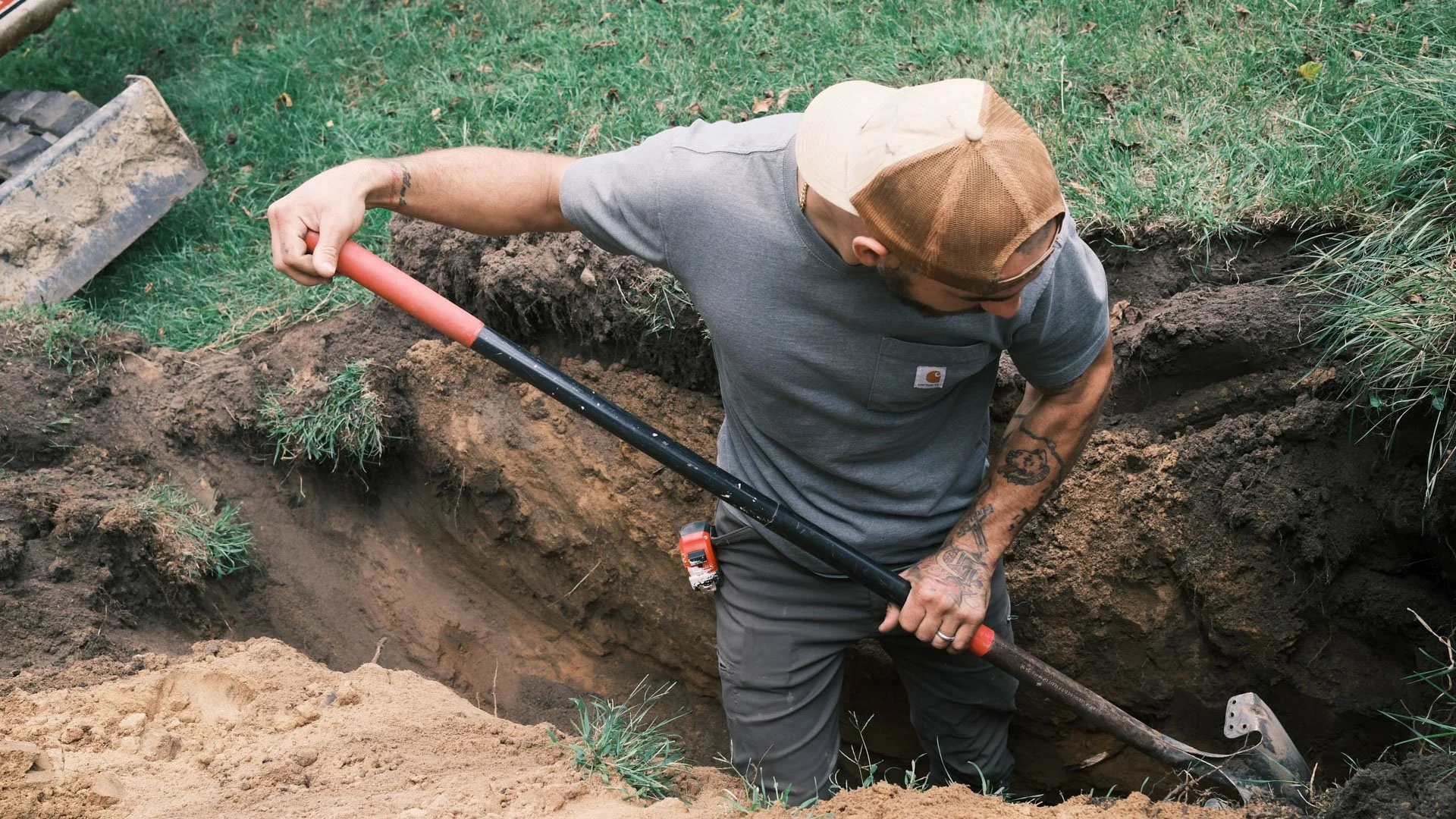 Man digging a trench in the ground with a shovel