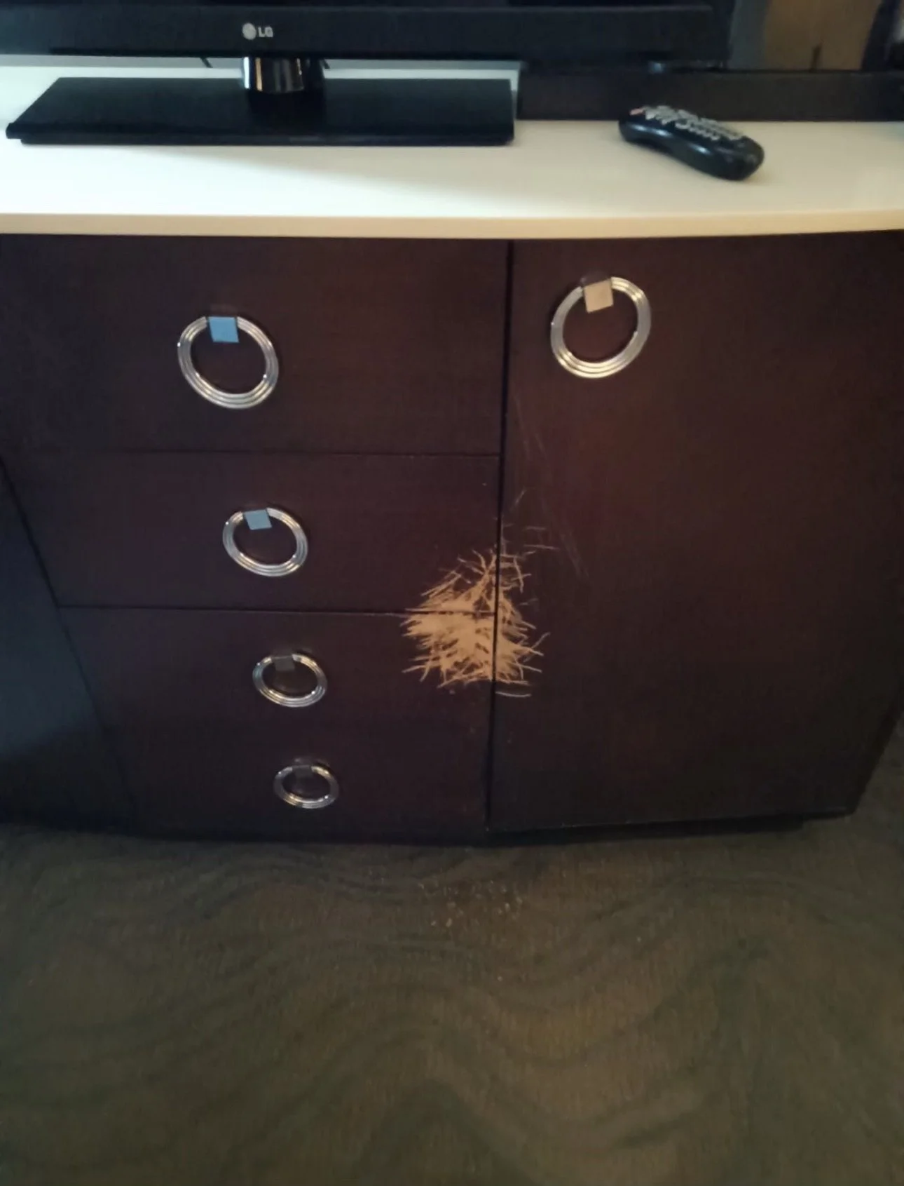 Severe structural and finish damage to luxury suite casegoods at WinStar World Casino and Resort in Thackerville, Oklahoma. This 'before' view showcases deep gouges and finish loss on a guest room dresser corner, demonstrating the high-impact wear ty