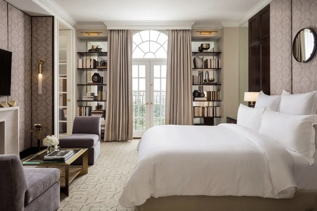 Luxury hotel suite FF&E installation by Tilia Design Co. featuring a professionally staged bed, seating area, and custom shelving.
