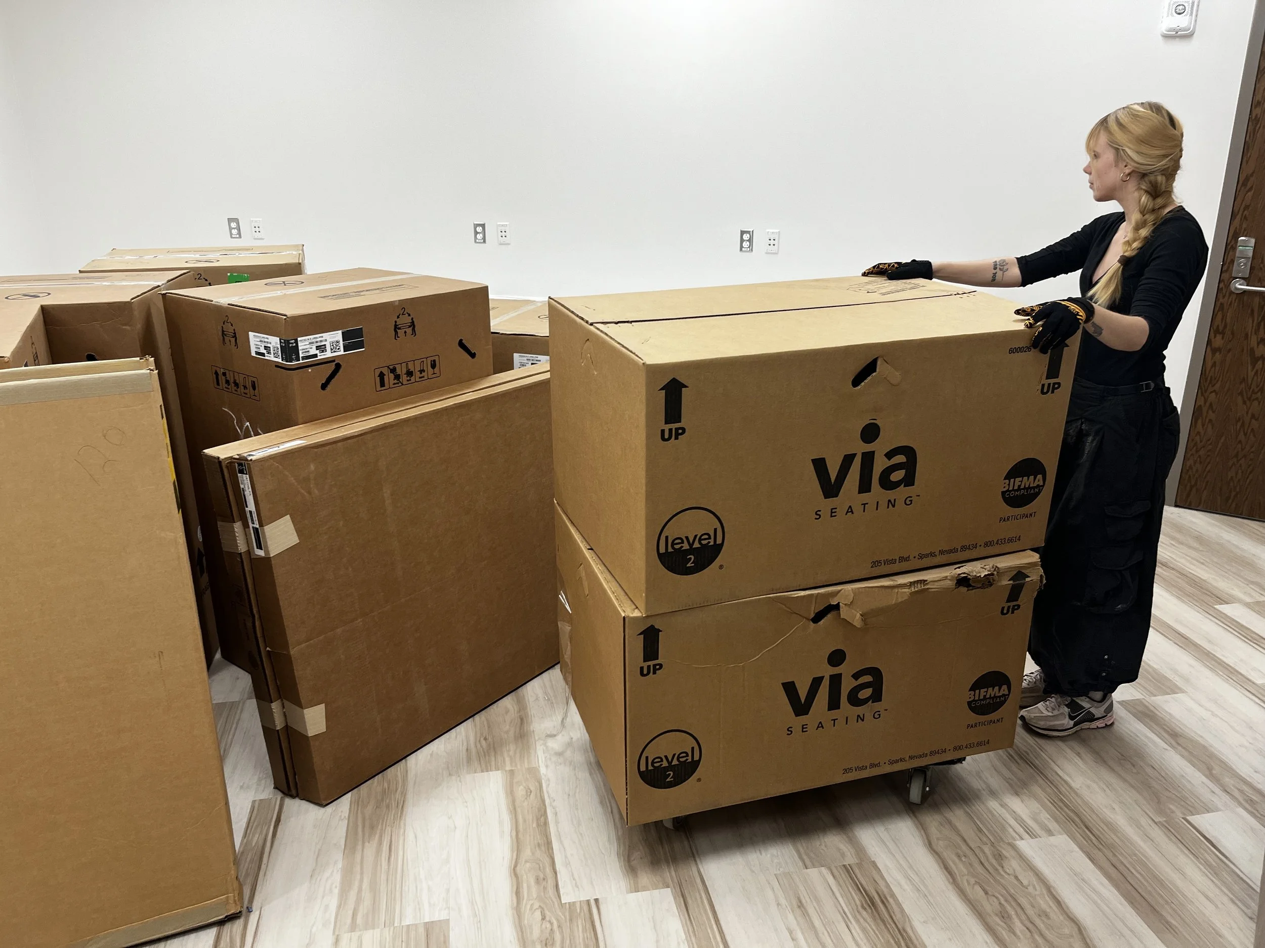 FF&E installation team carefully placing luxury office furniture and VIA Seating assets onsite for a commercial project in OKC.