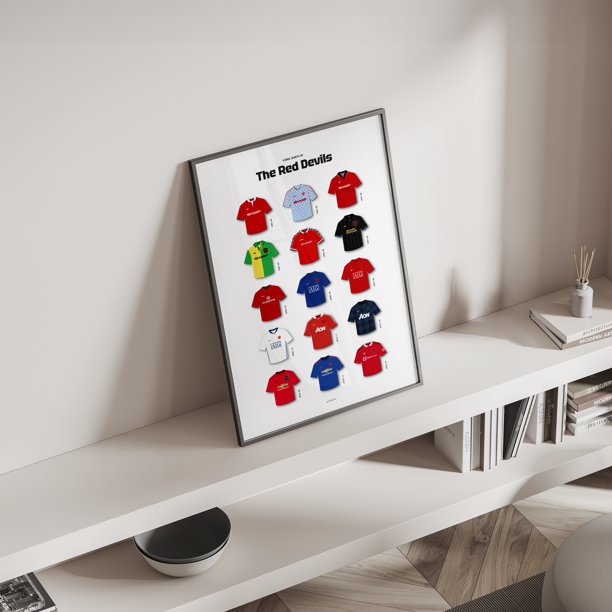 The Red Devils iconic kits poster standing on a shelf