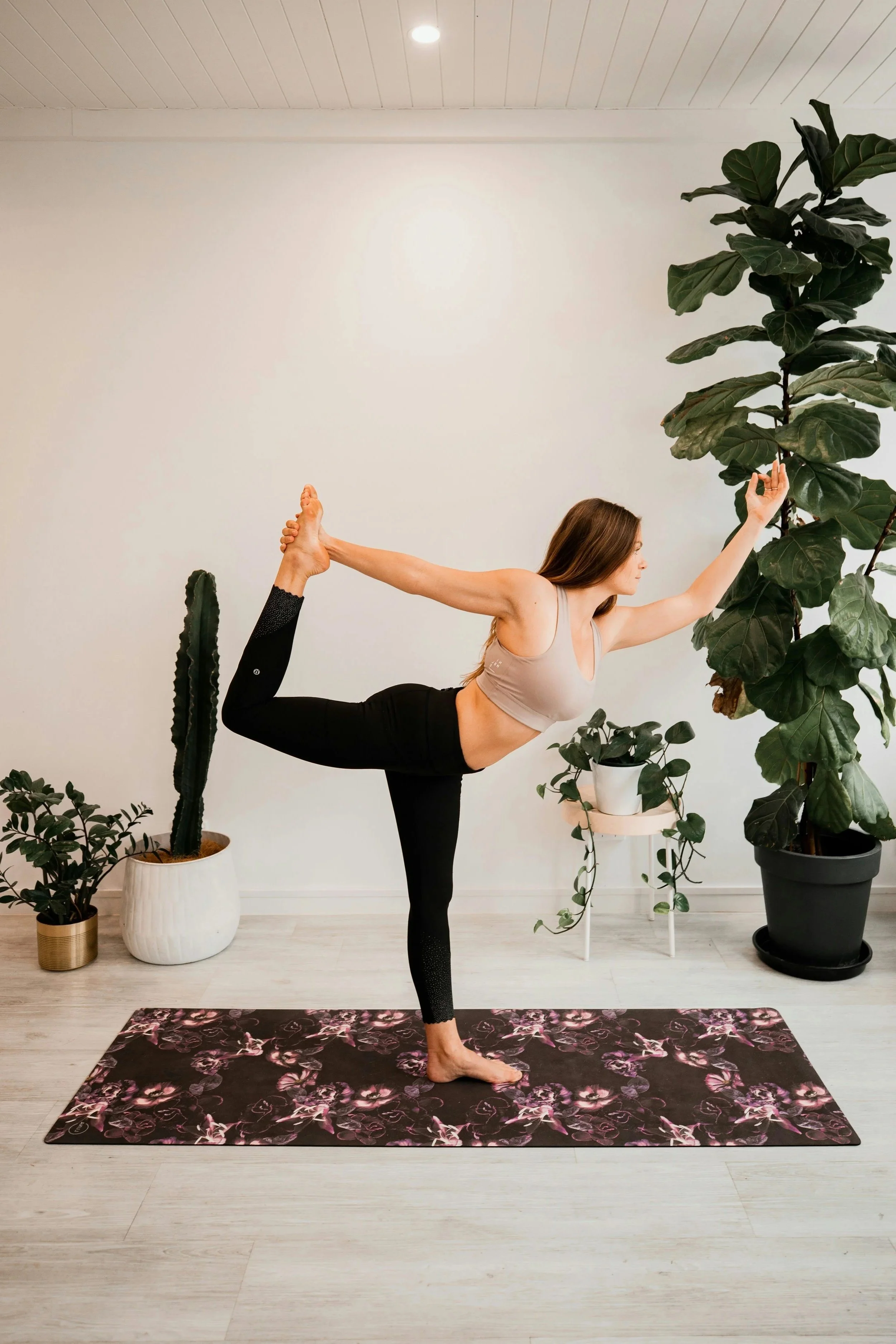 Femme pratiquant le yoga dans une pièce avec plantes
