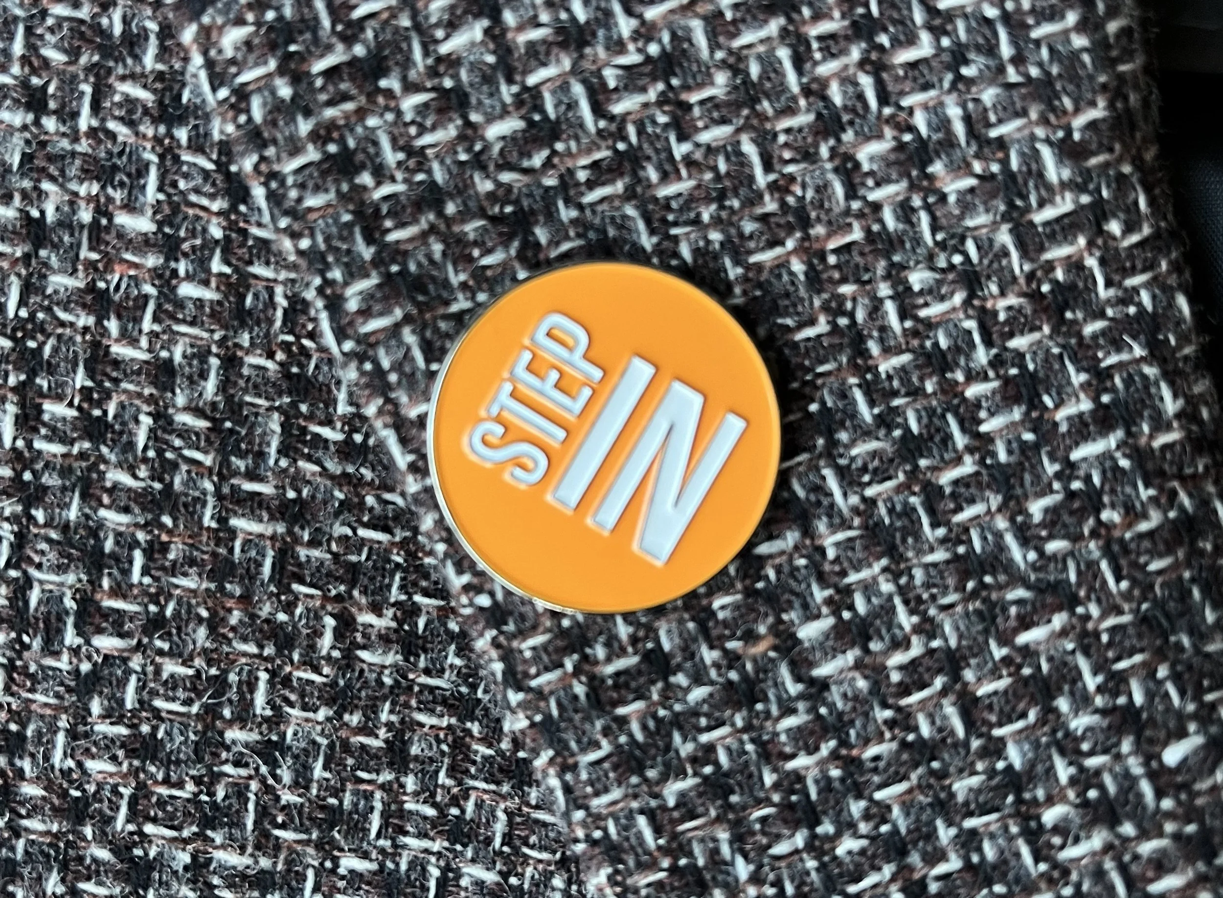 Orange step in pin badge.