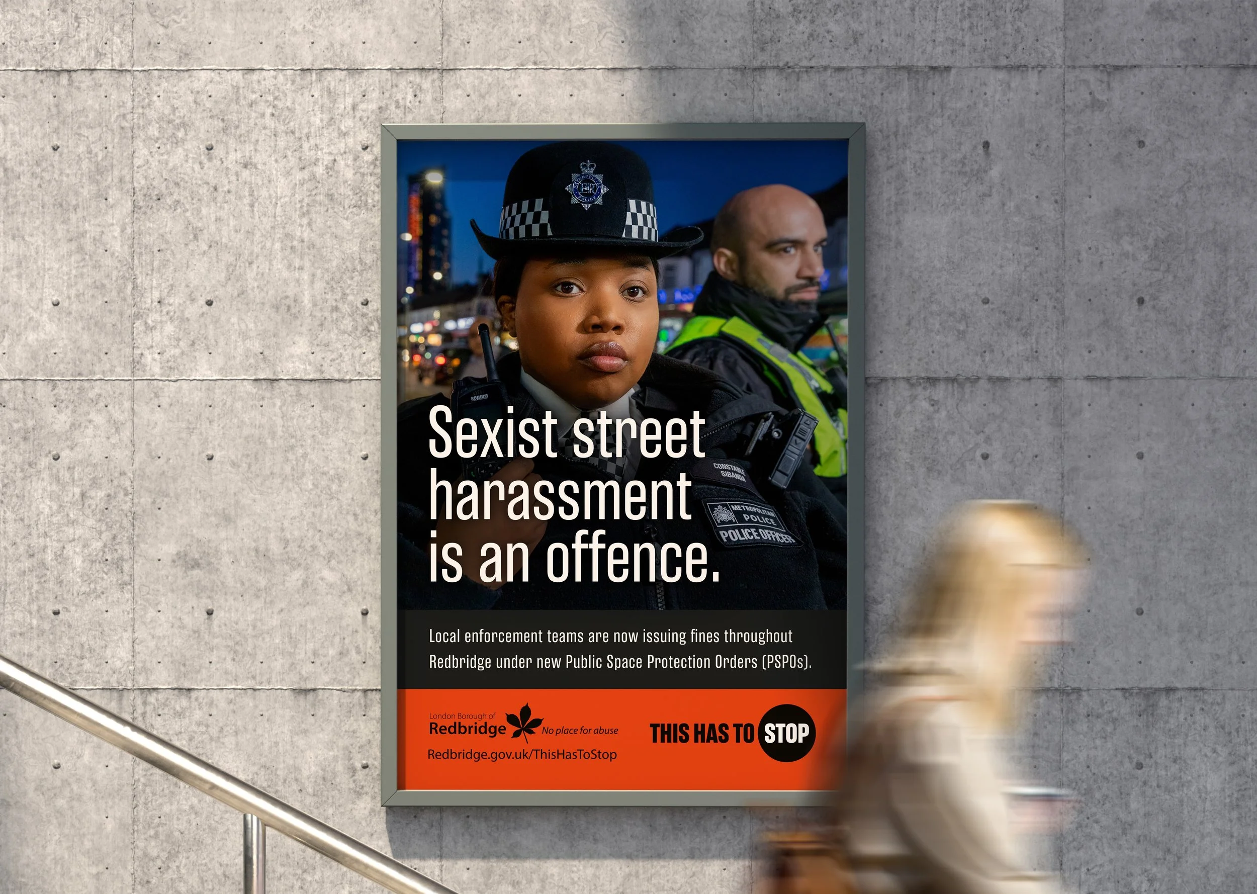 A showing two police offers in front of a recognisable Redbridge landmarks. The policewoman is looking directly at the viewer. The poster reads 'Sexist street harassment is an offence.'